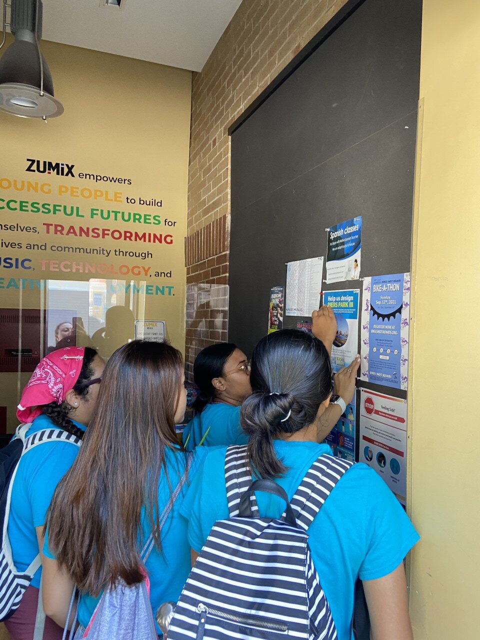  This is a picture of the Ambassadors hanging flyers around East Boston as a way of community outreach. We made flyers and surveys and went around and hung them in the businesses of East Boston, to gather feedback from local teens about the future de