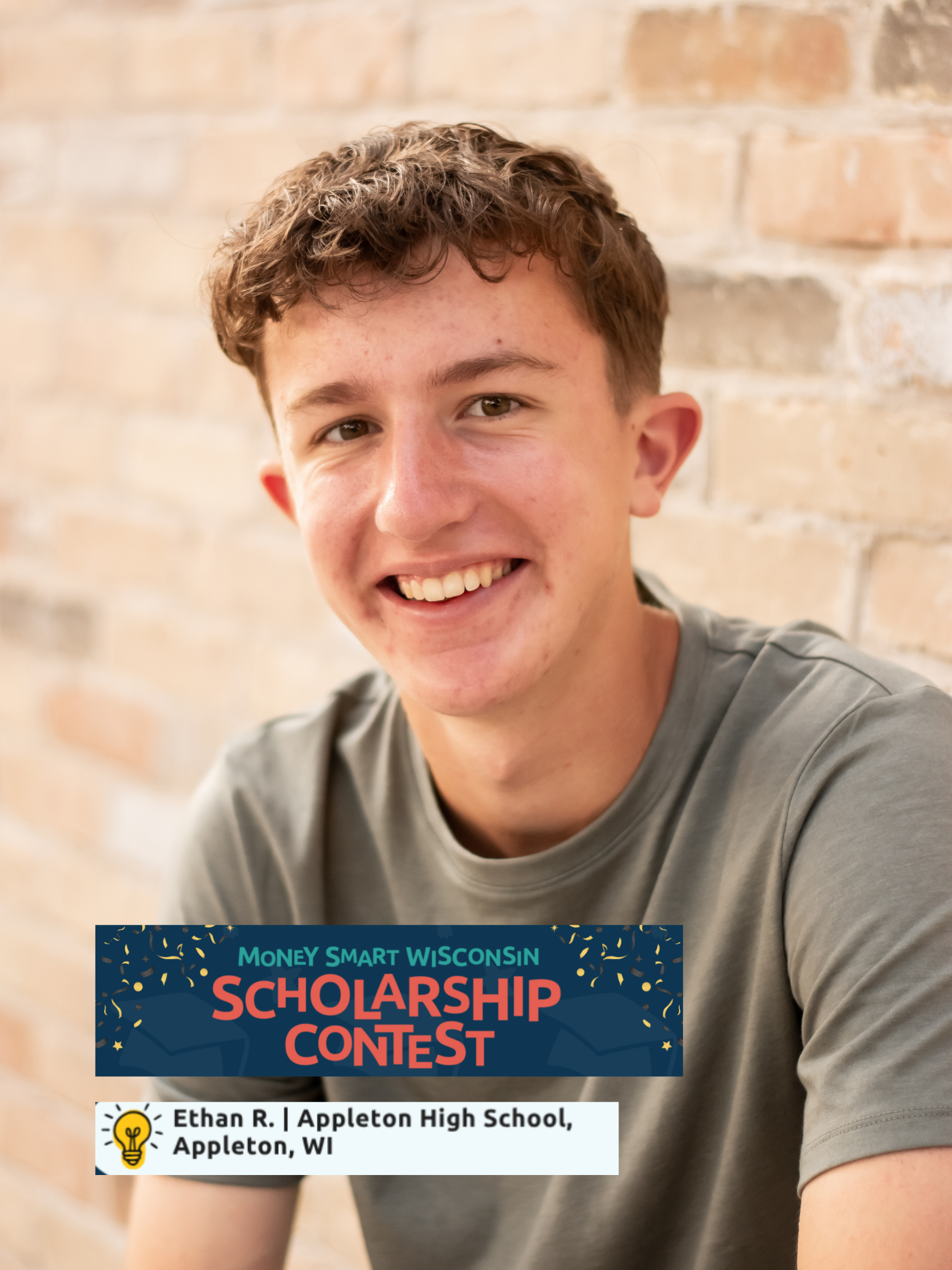 A young male smiling in front of a brick wall, holding a sign that reads 'Money Smart Wisconsin Scholarship Contest'. The sign also includes his name, Ethan R., and his school, Appleton High School in Appleton, WI.