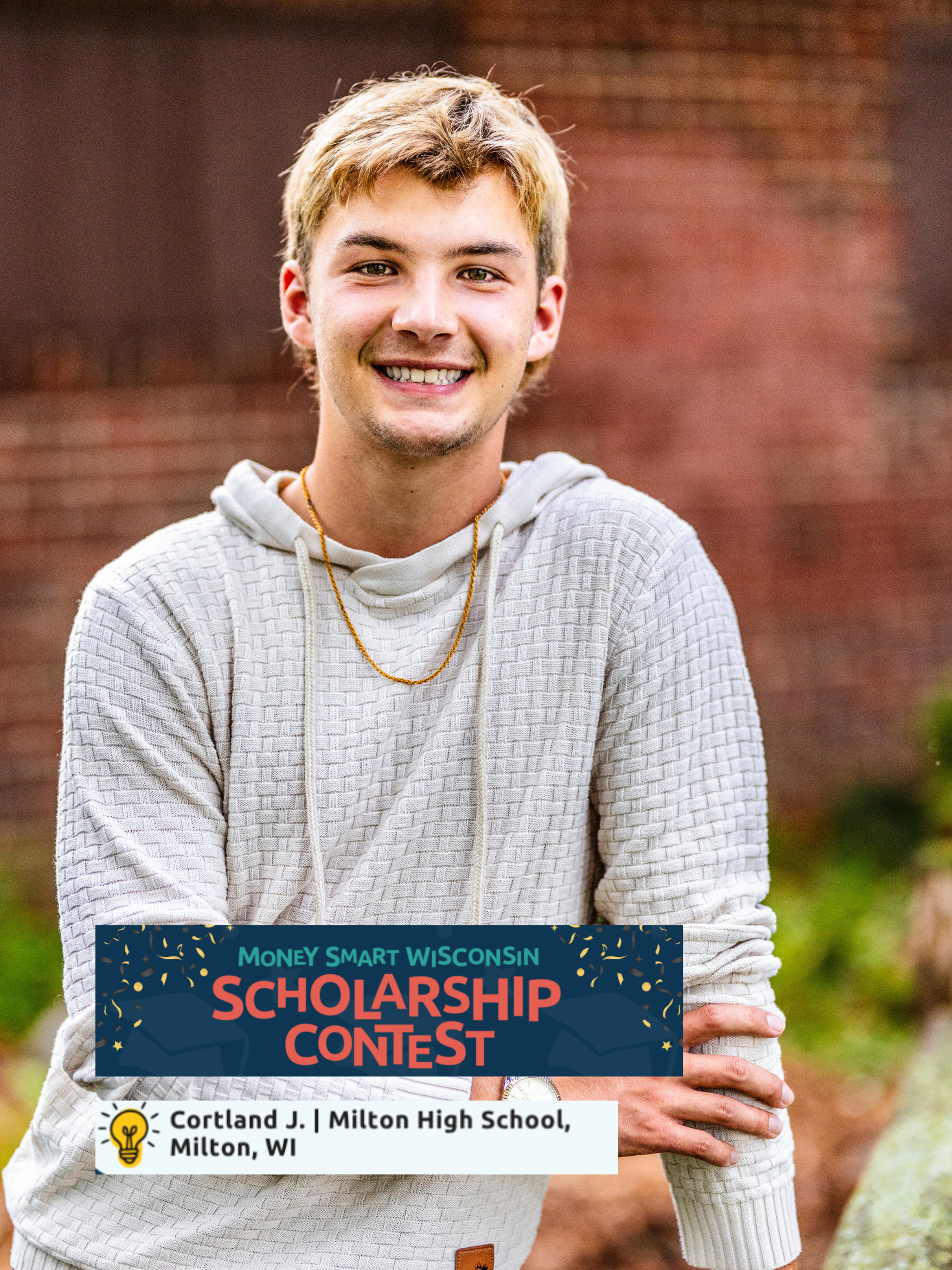 A young man with blond hair smiling outdoors in front of a brick wall, wearing a beige hoodie, with a scholarship contest banner overlayed at the bottom of the image.