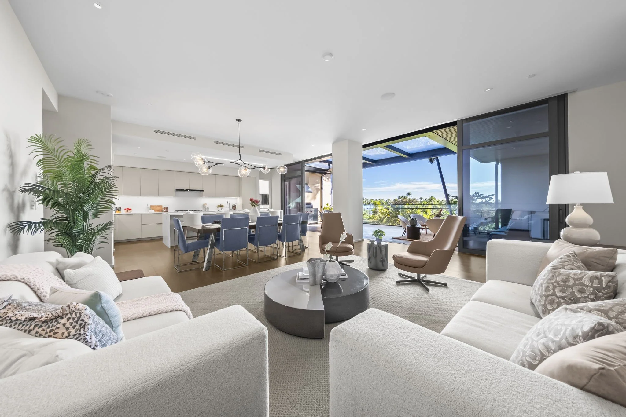 Professional MLS photography of a modern luxury living room and dining area with natural light and ocean views on Oahu