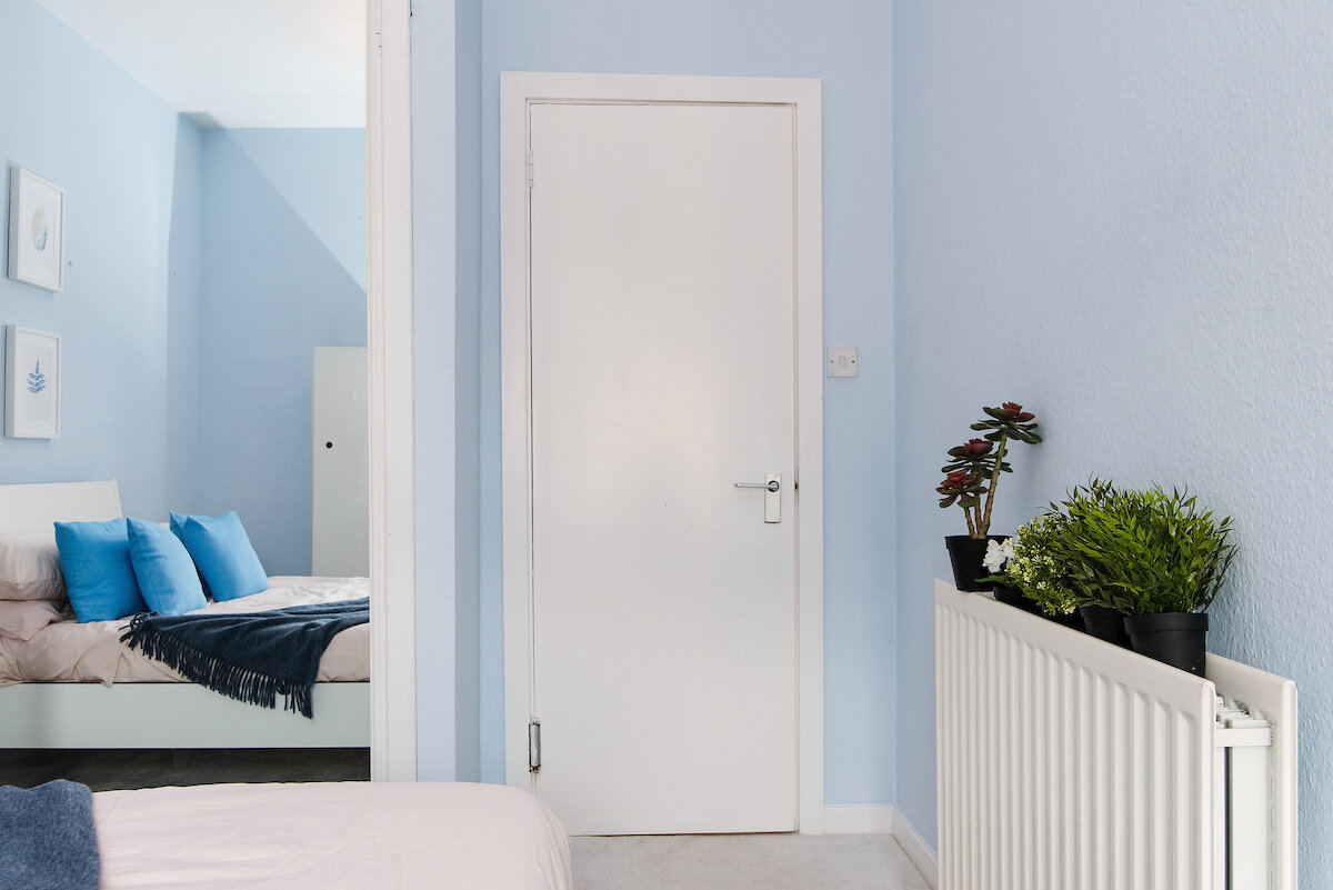 blue walls bedroom, mirror, throw and cushions