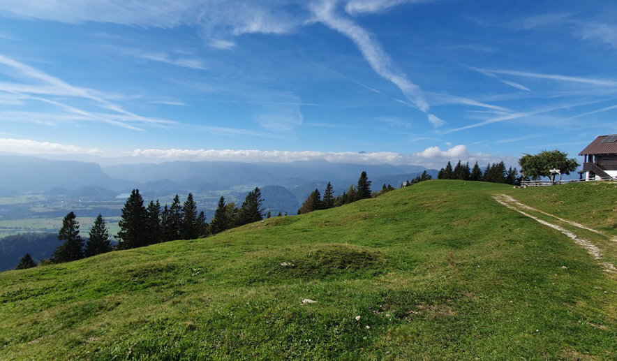 Blick von der Zabreska-Alm auf Bled und den wolkenverhangenen Triglav