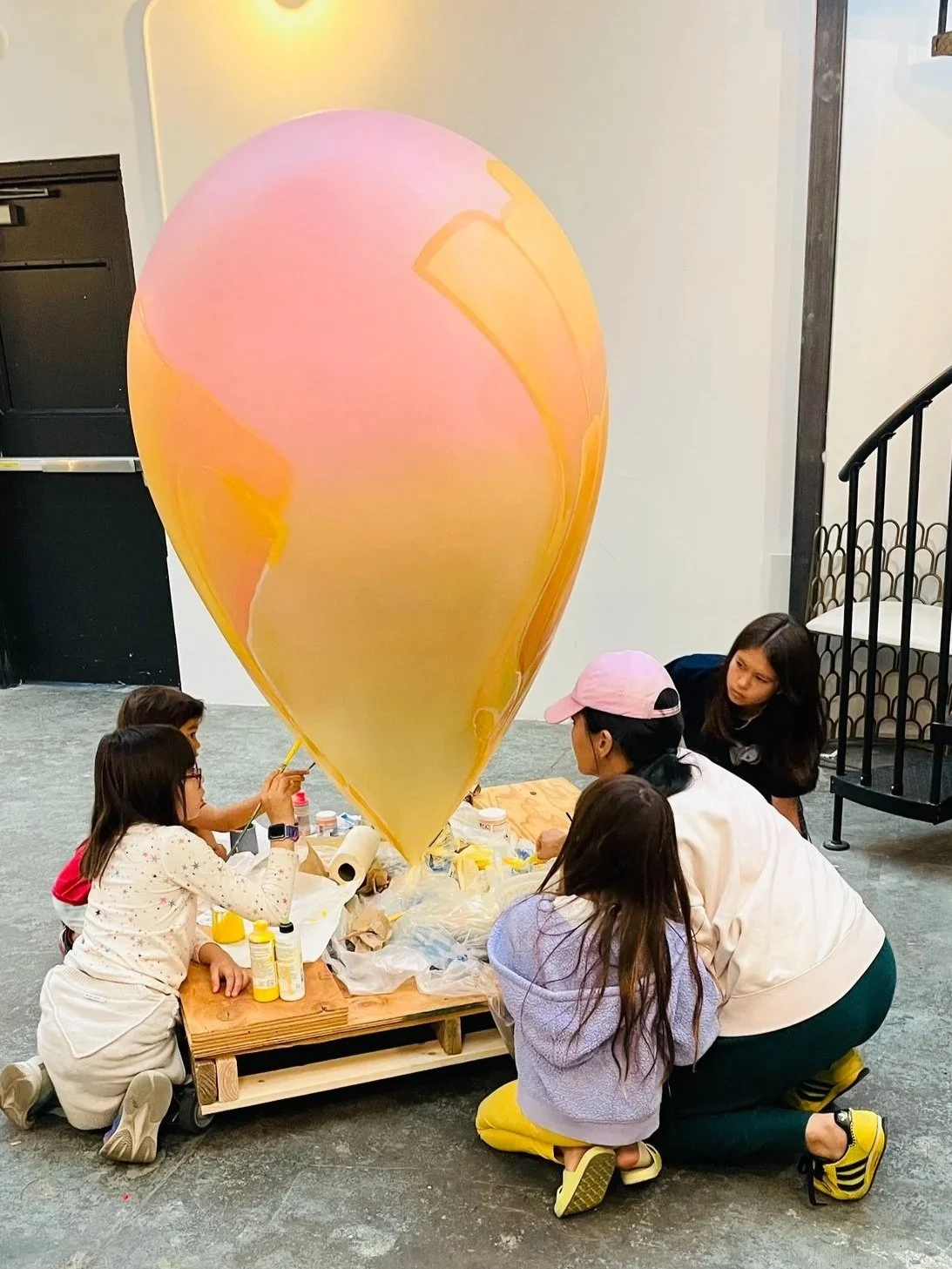 Community members painting the SŌL heart sculpture with Dev Heyrana at her Ciel Creative Space studio in Berkeley, California, a commission for the San Francisco General Hospital Foundation