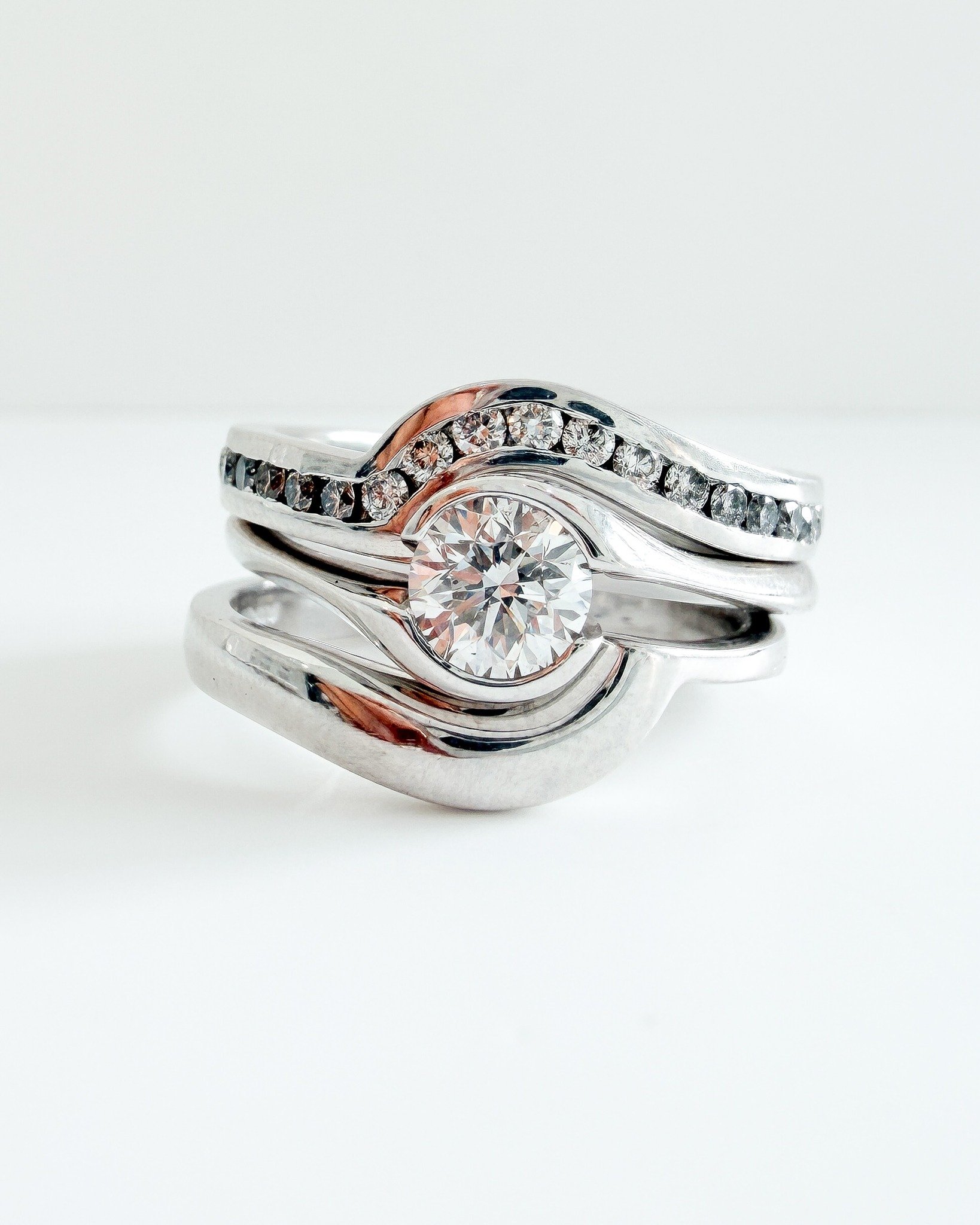 Fitted wedding and eternity rings are made to hug your engagement ring perfectly, custom-made for your unique design! ✨

This beautiful set features a partial rubover set bypass engagement ring with a plain fitted wedding ring and channel set diamond