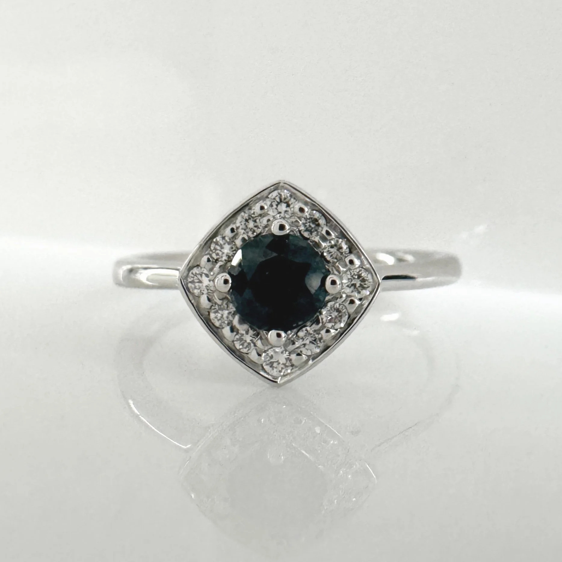 Teal sapphire and diamond halo ring