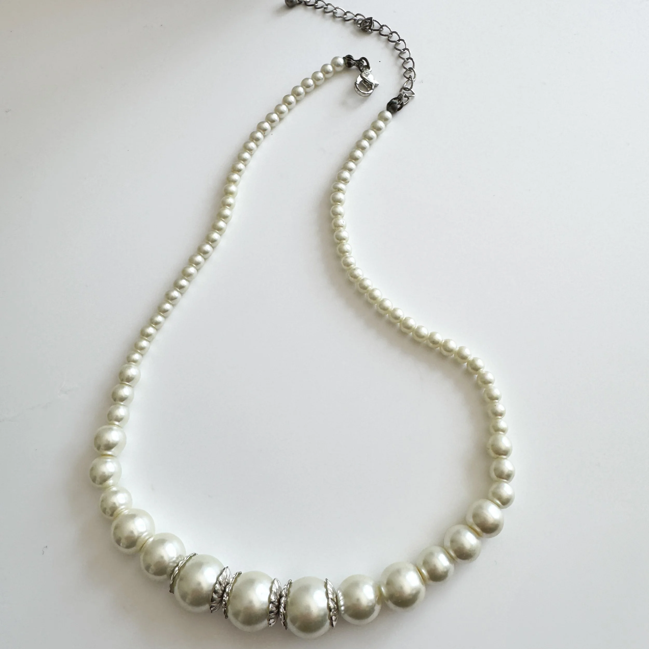 a photo of the pearl necklace lying down with round trigger clasp in view