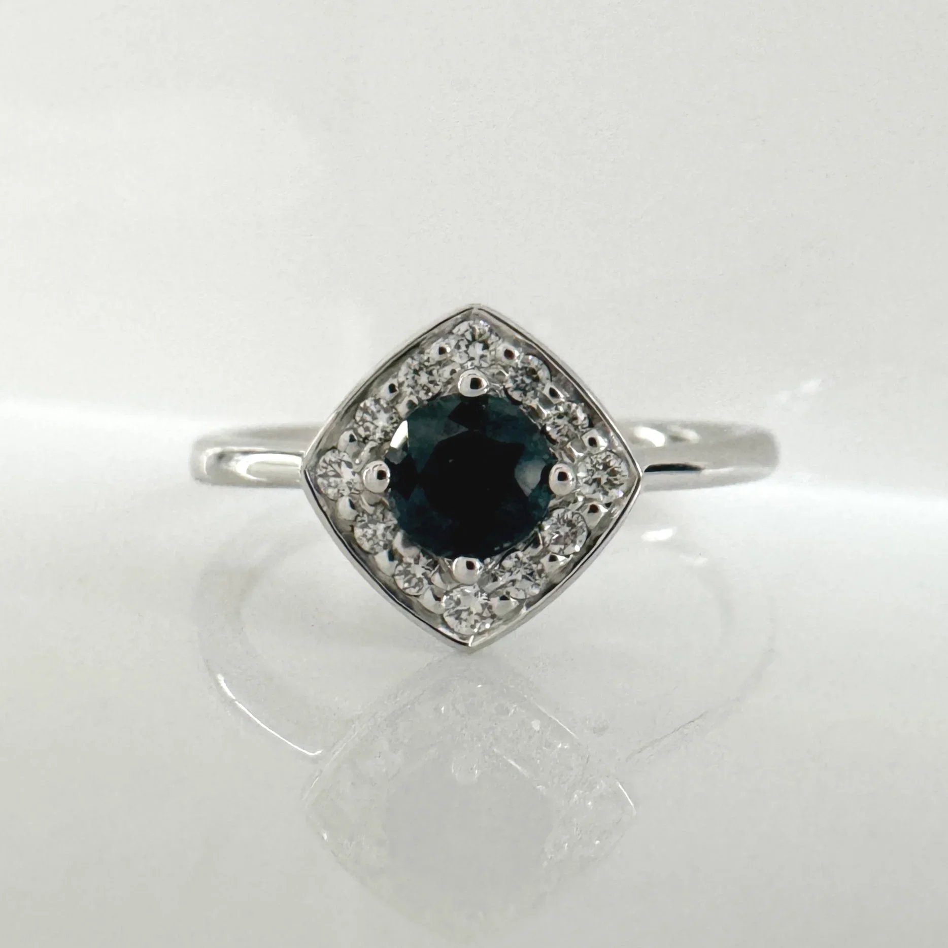 Teal sapphire and diamond halo ring
