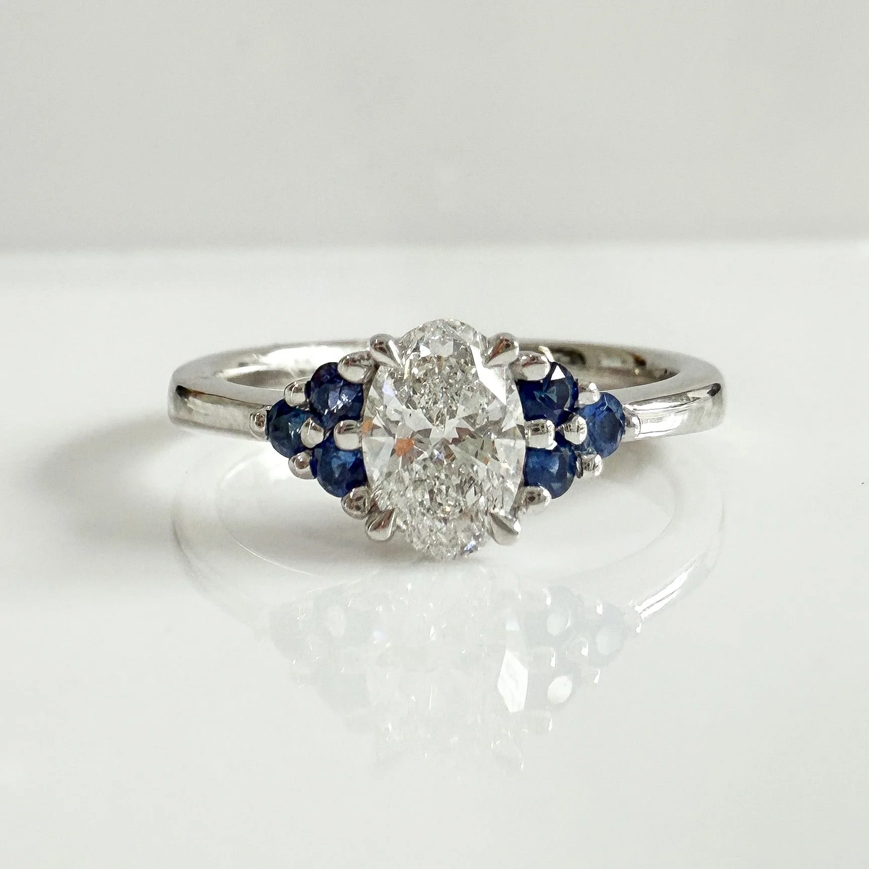 Oval diamond and round sapphire platinum ring