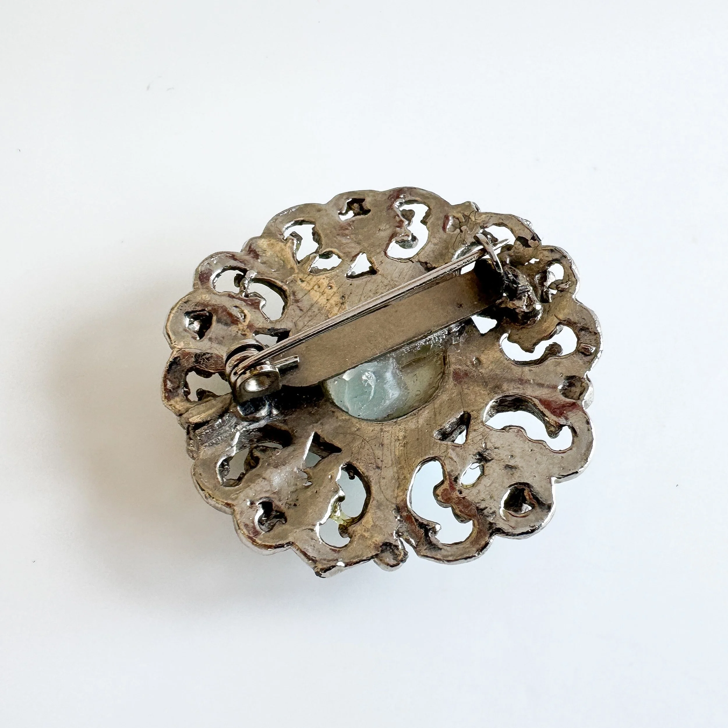 A photo of the back of the brooch which shows it has a pin fastening