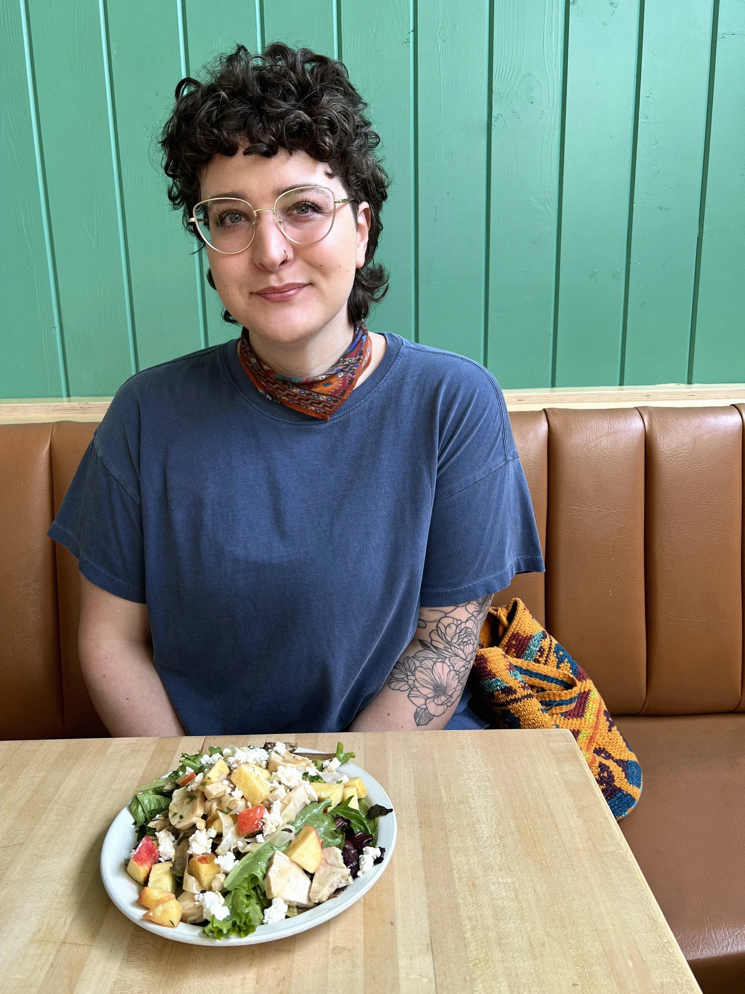 Person sitting at a restaurant table with a salad