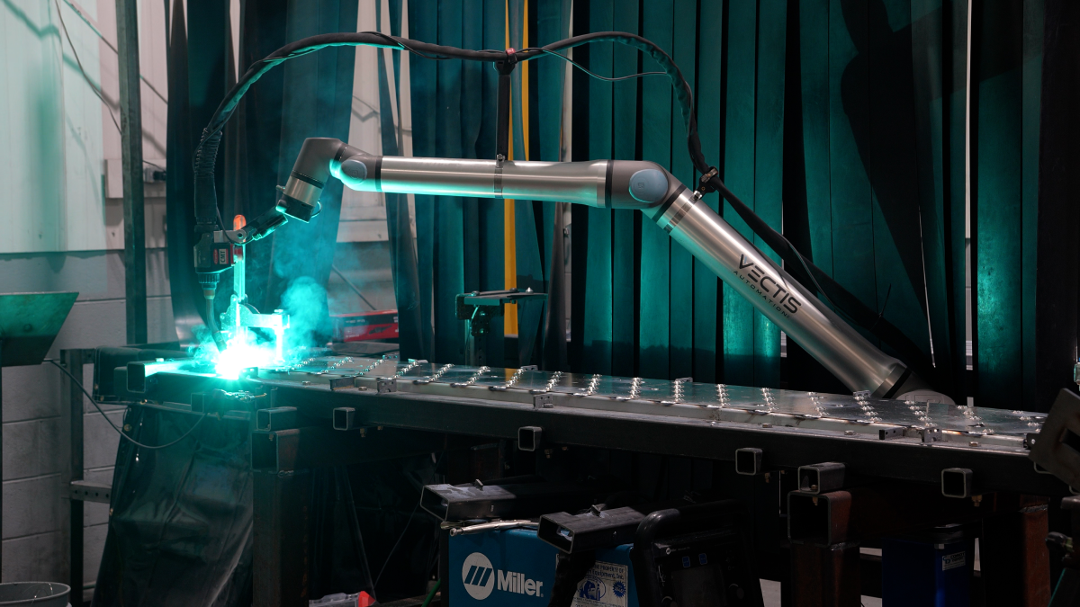 Cobot welding system performing aluminum welding on a fabricated component with visible arc and shielding gas, supporting consistent weld quality on lightweight and repeatable aluminum parts.