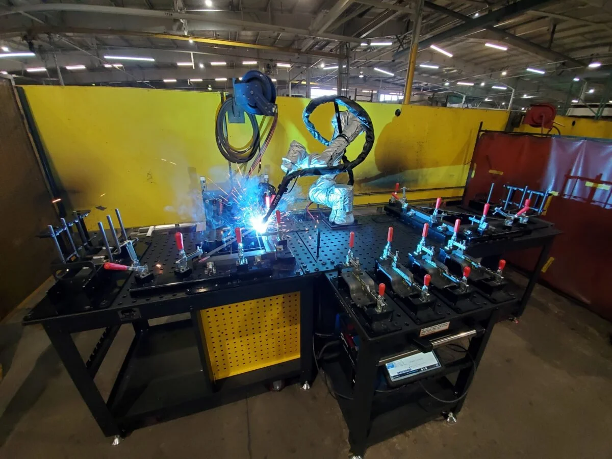 Collaborative robotic welding system performing a weld on a fixtured part at a manufacturing facility.