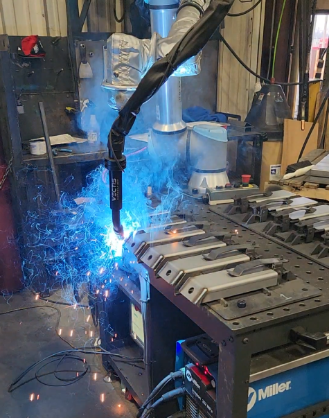 Vectis cobot welding a series of metal parts in a fabrication shop.