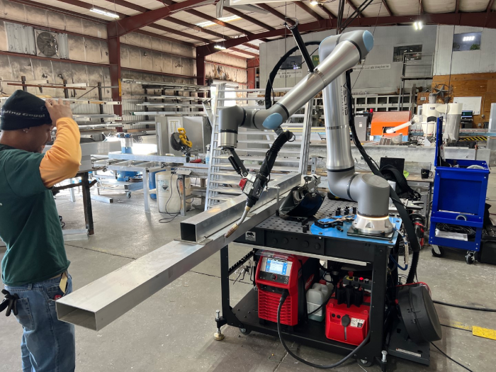 Collaborative welding system fabricating an aluminum component in a production environment