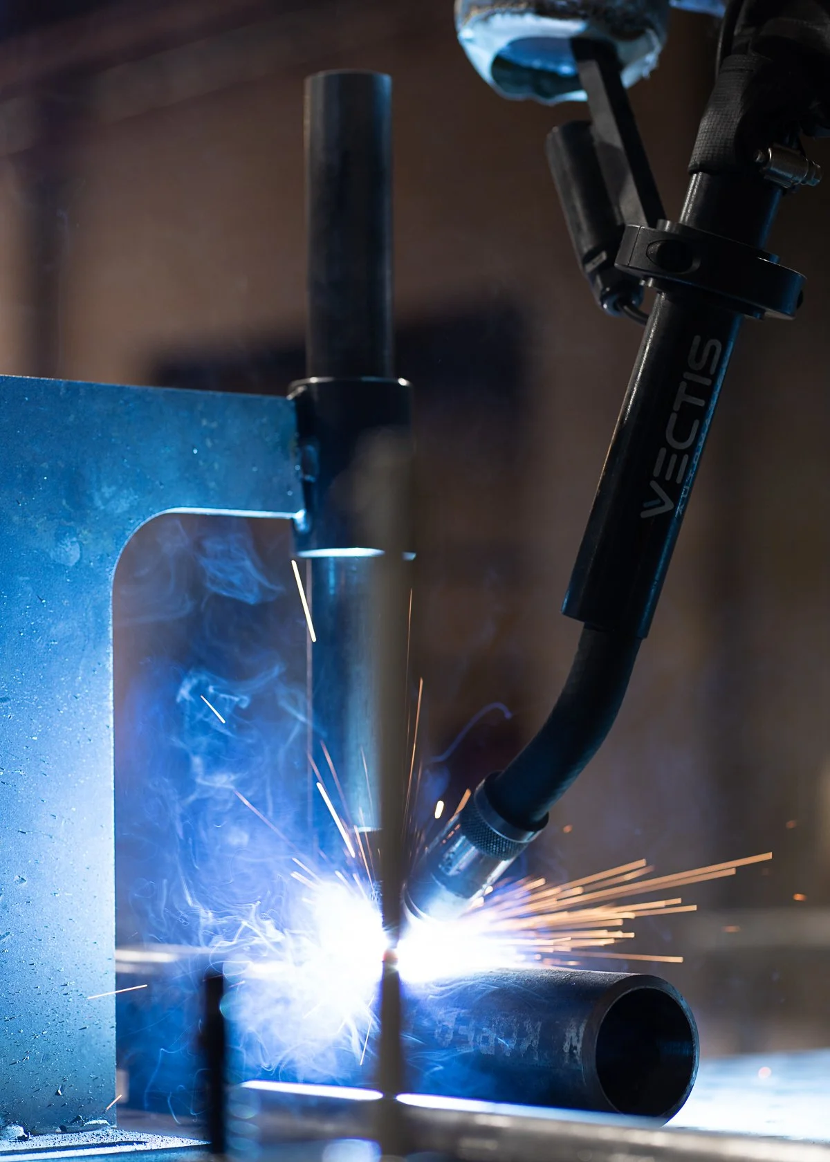 Vectis cobot welding system welding a fixtured metal part at CM Welding during medium-volume batch production.
