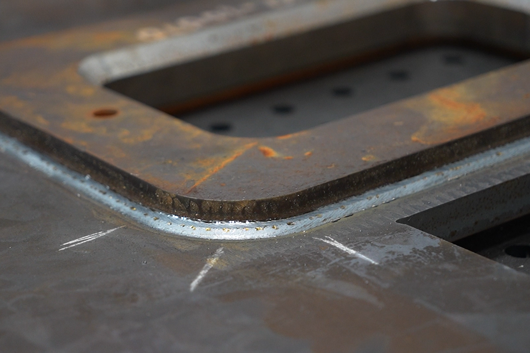 Close-up of a finished weld around the corner of a steel frame at KYJO Steel.