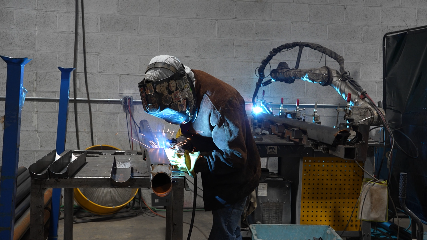 Welder works alongside Vectis collaborative robot at Caltech Manufacturing