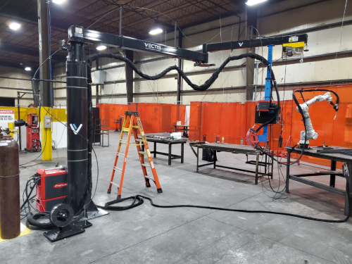 Vectis welding automation boom extended over a fabrication work area.