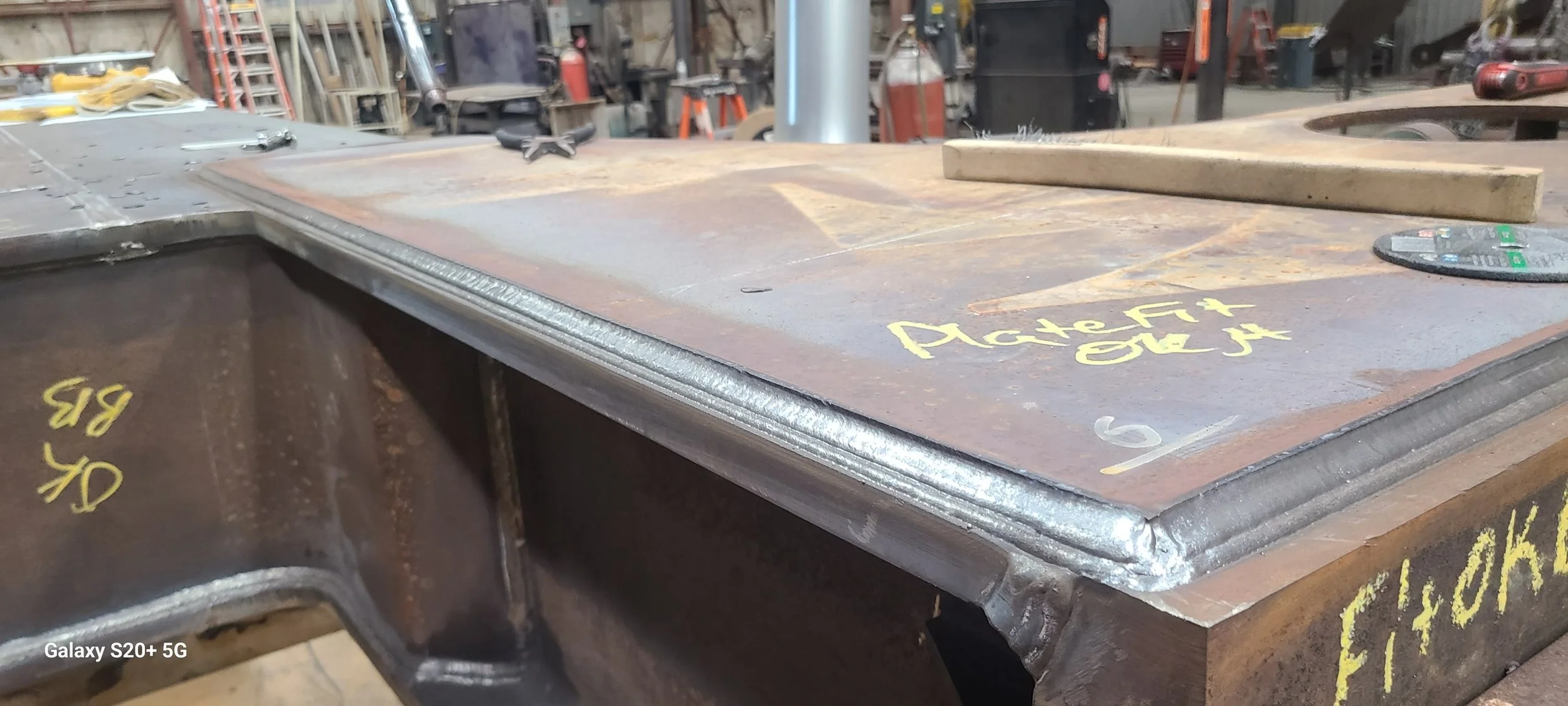 Close-up of a multipass weld seam on a steel plate after a robotic welding application.