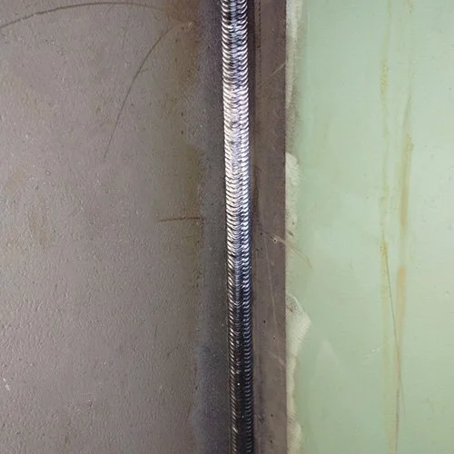 Heavy multipass weld along a structural steel joint for bridge fabrication.