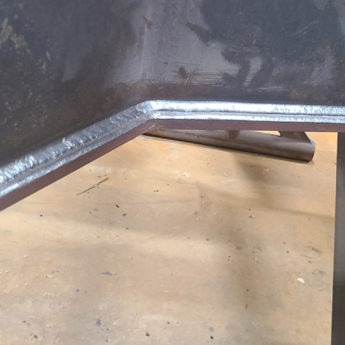 Multipass FCAW fillet weld along an angled steel joint in the 2F welding position.
