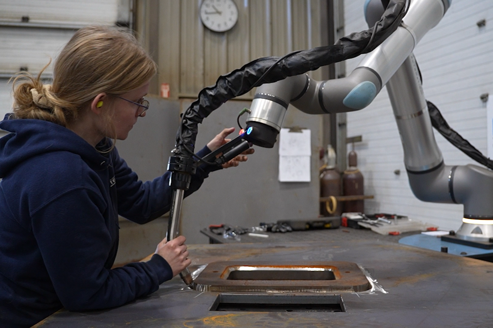 Operator positions the welding torch on a Vectis cobot welding system at KYJO Steel.