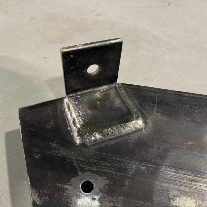 Welded structural steel bracket attached to a heavy steel base plate.
