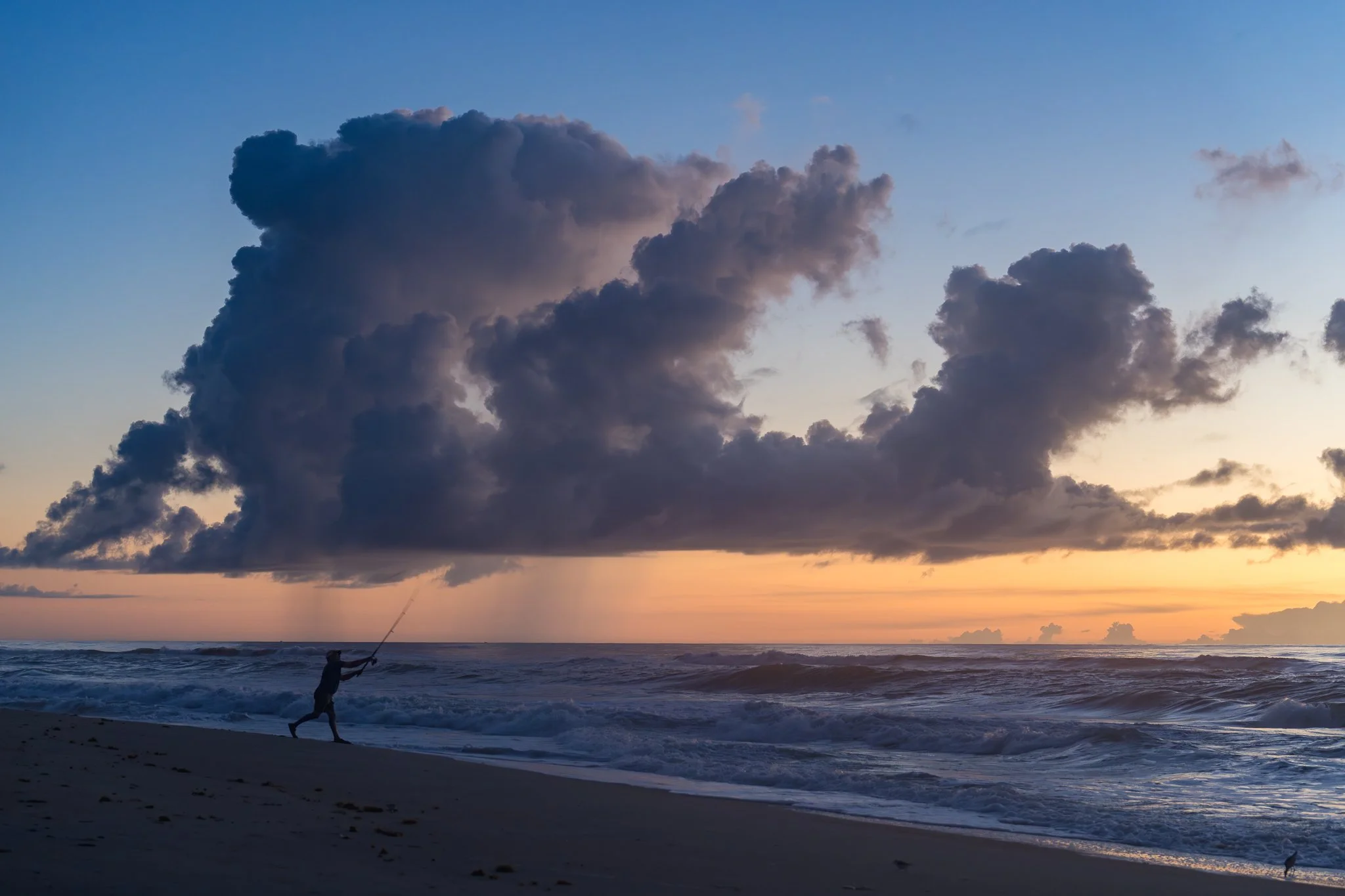 Sea mist clung to the morning air, offering everything a fog like glow.  The scene felt like a collection of stories woven together&mdash;the fisherman&rsquo;s silhouette, the rain falling from dramatic offshore clouds, and the sky itself, filling wi