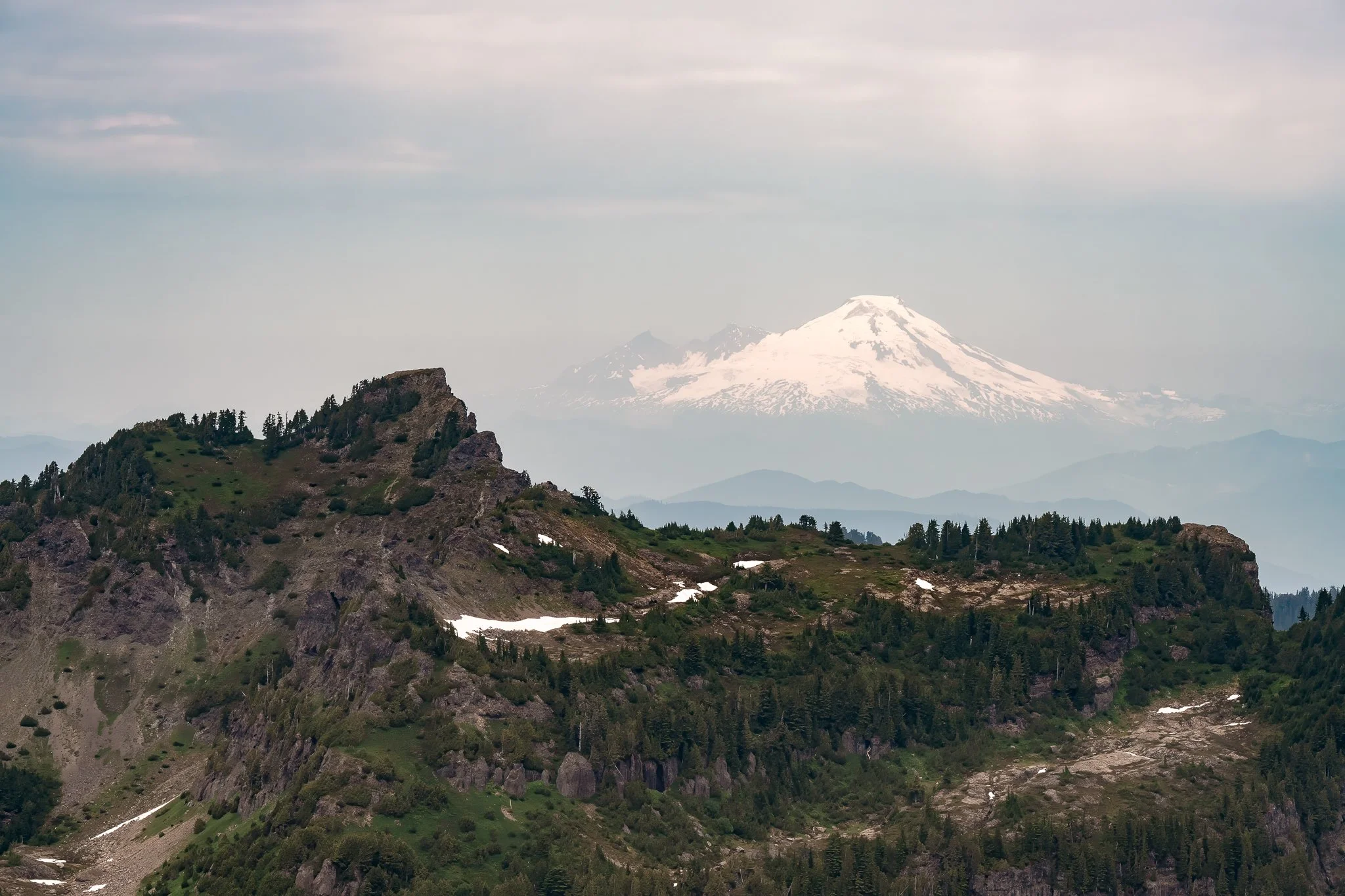 View of Mount Baker volcano in the distance and the rocky ridge of Big Four Mountain from the Mount Dickerman hiking trail in Washington.