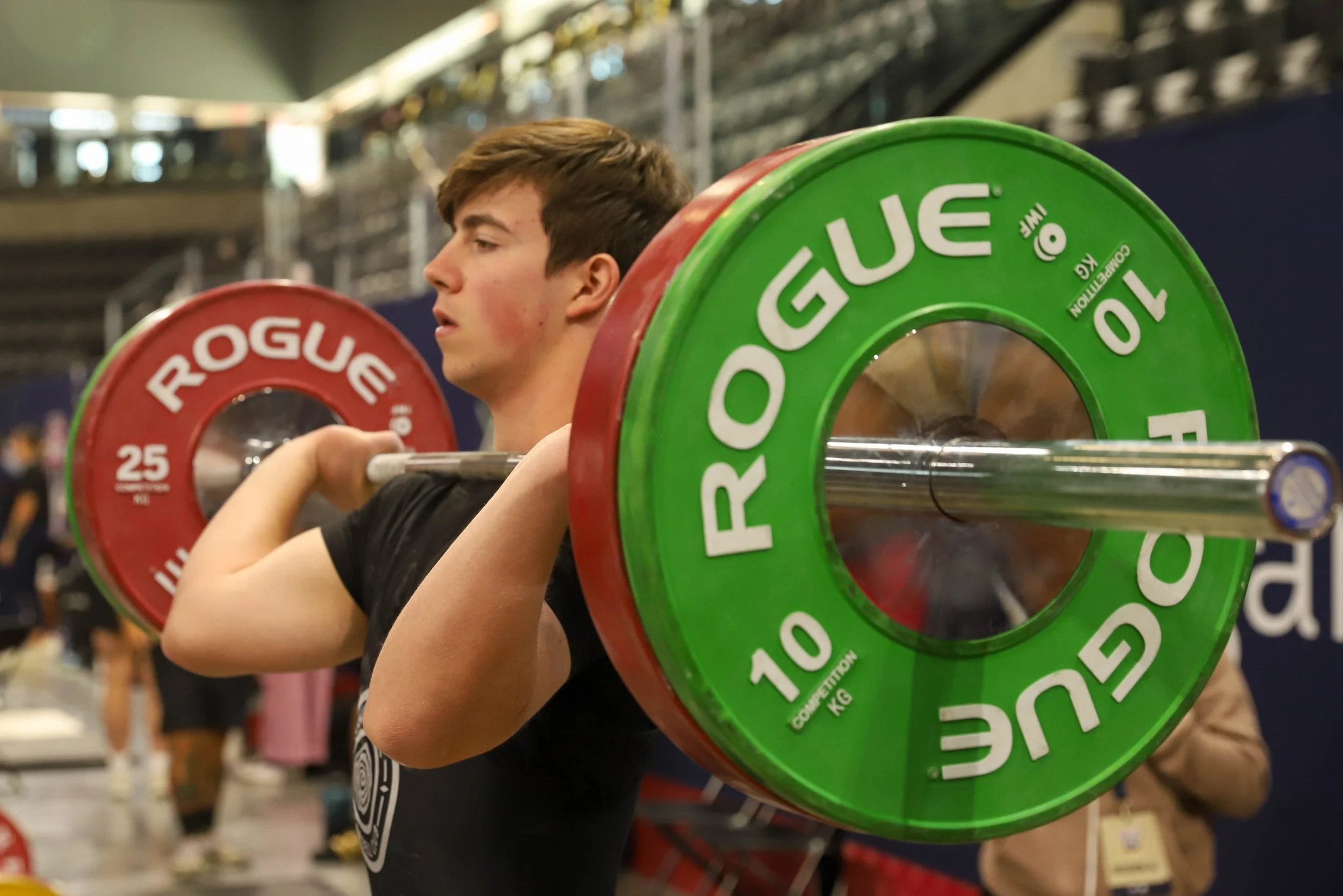 Young man with 90 kilos in front rack prepares to jerk.