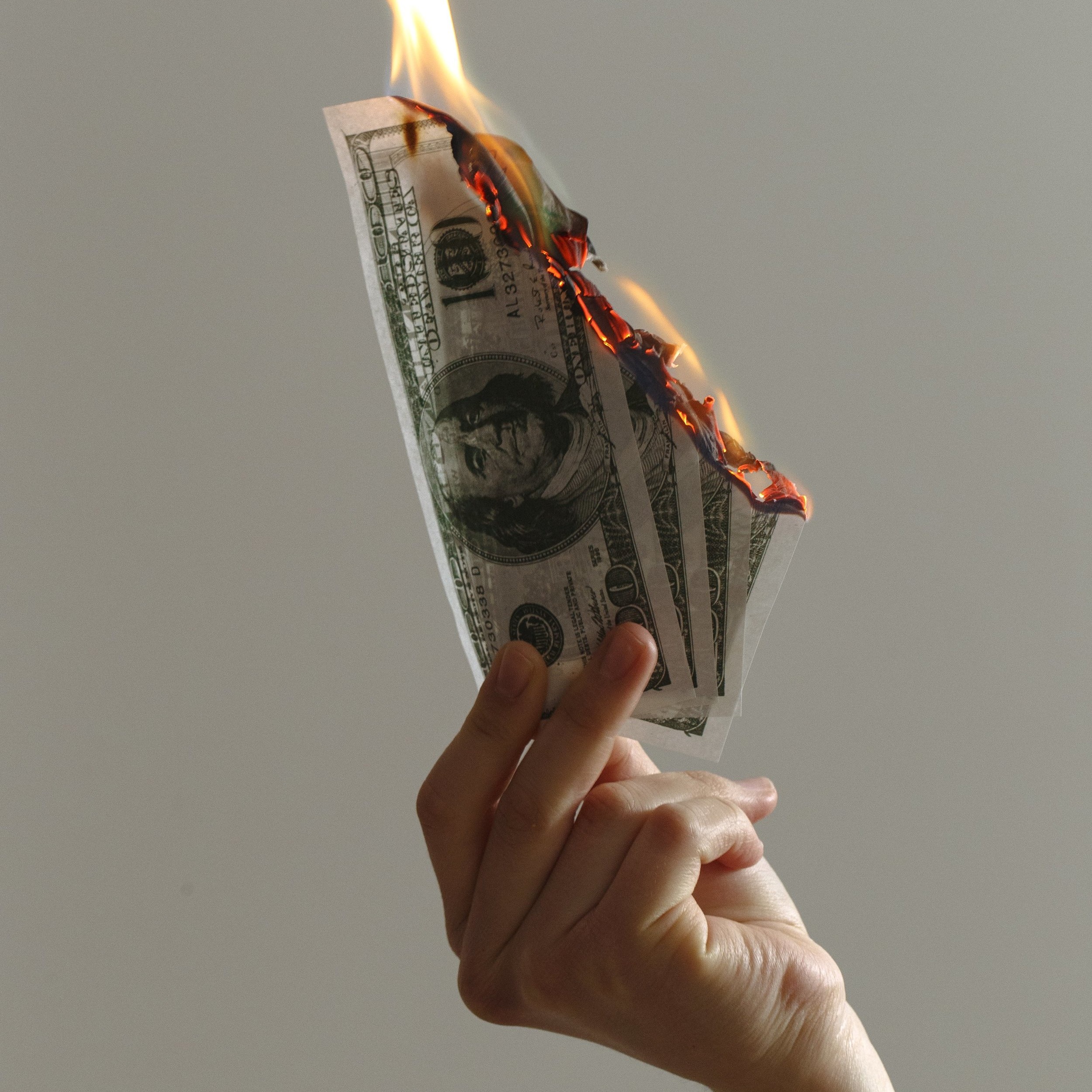 a-single-hand-holding-up-burning-notes.jpg