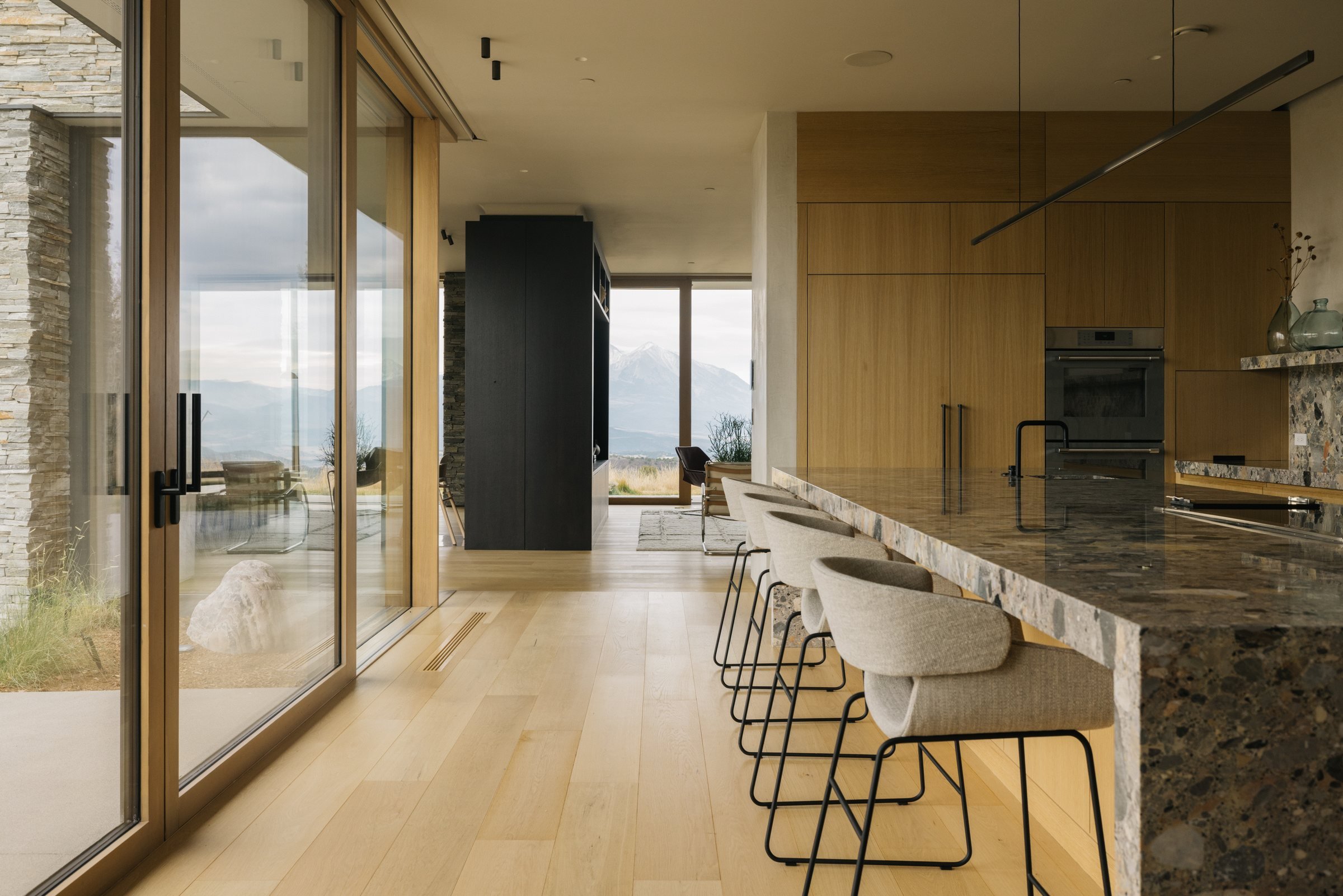 Kitchen with a marble island and windows to the terrace
