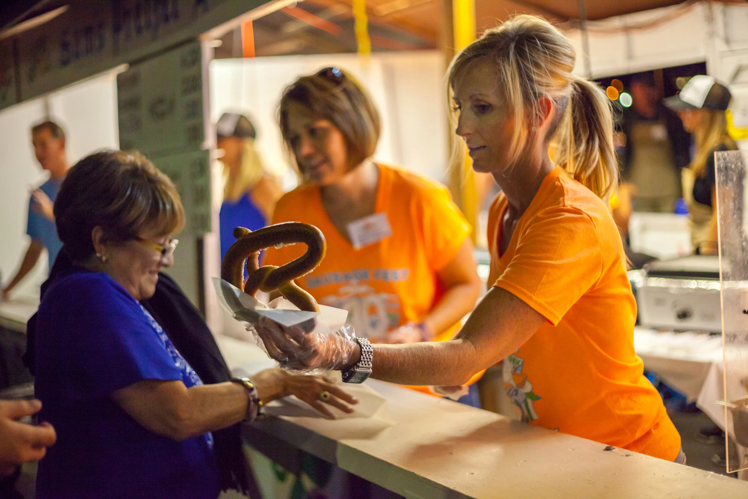 A customer receives a pretzel from Sam’s place, a popular booth for hot treats