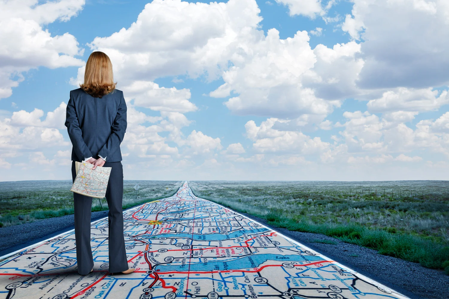 Businesswoman-Stands-On-Long-Road-With-Road-Map-Painted-On-It-614711200_5472x3644.jpg