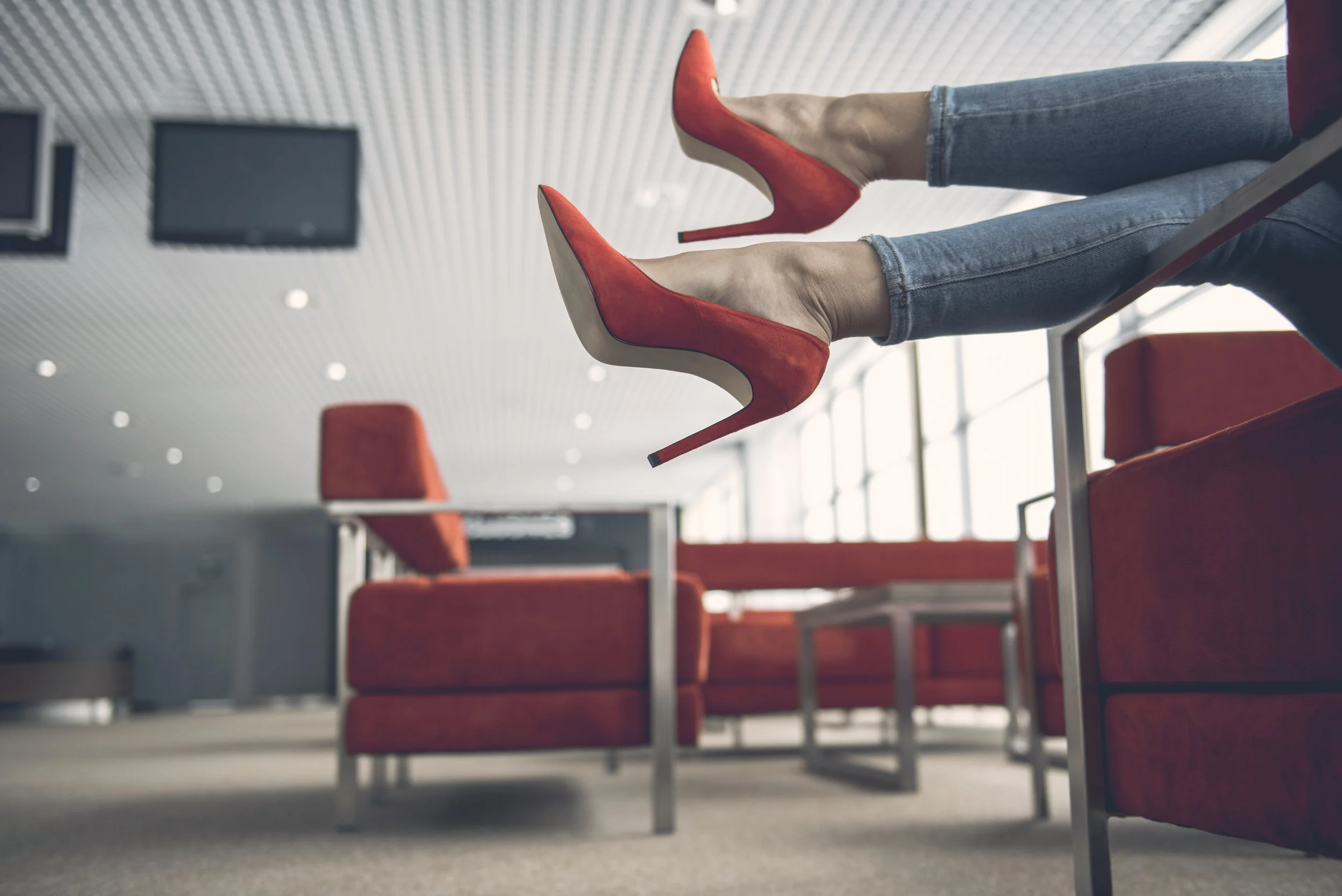 Woman-feet-locating-in-modern-lounge-zone-955686628_6016x4016.jpeg