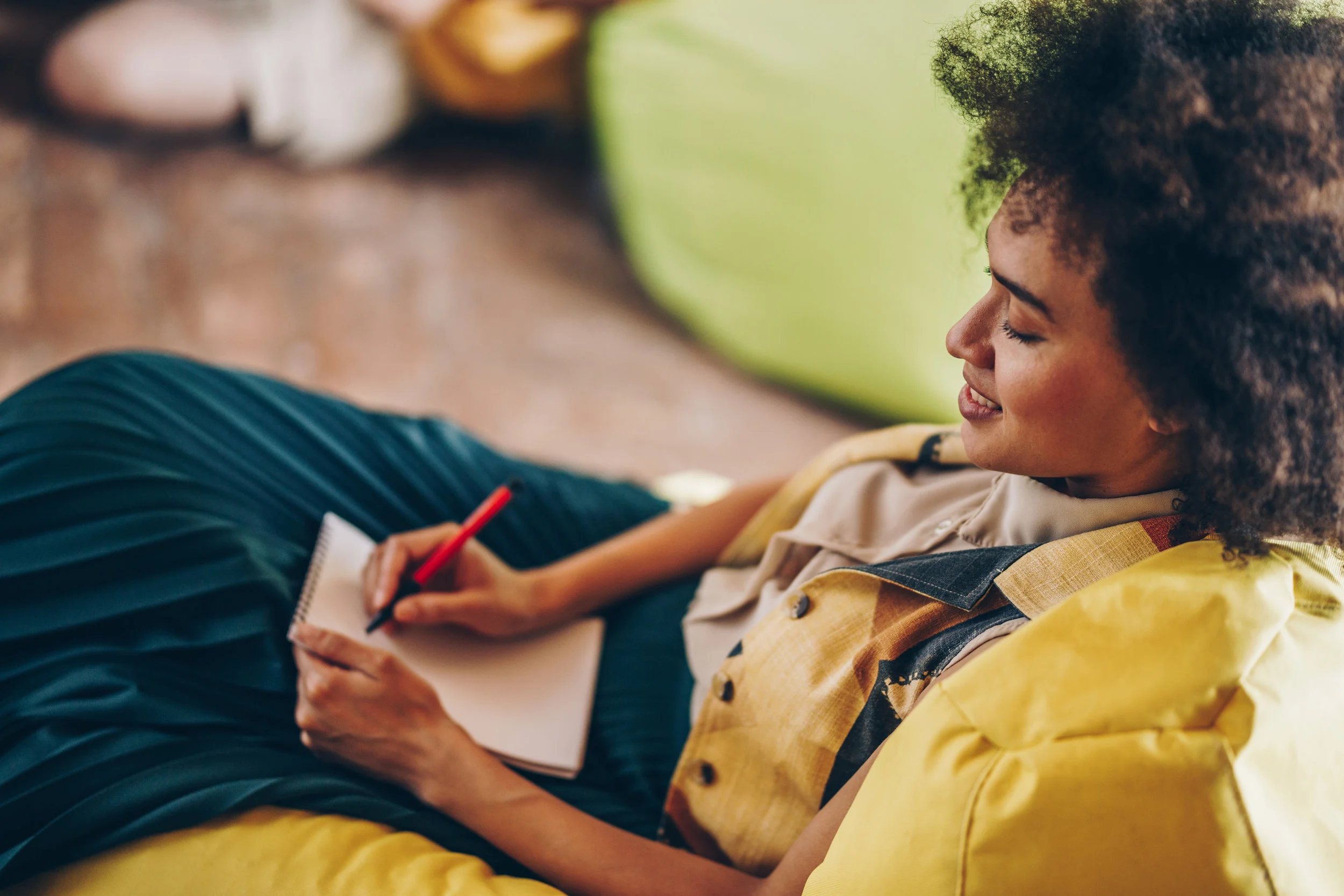 Happy-African-American-woman-taking-notes-in-a-notebook.-978978290_3869x2579.jpeg
