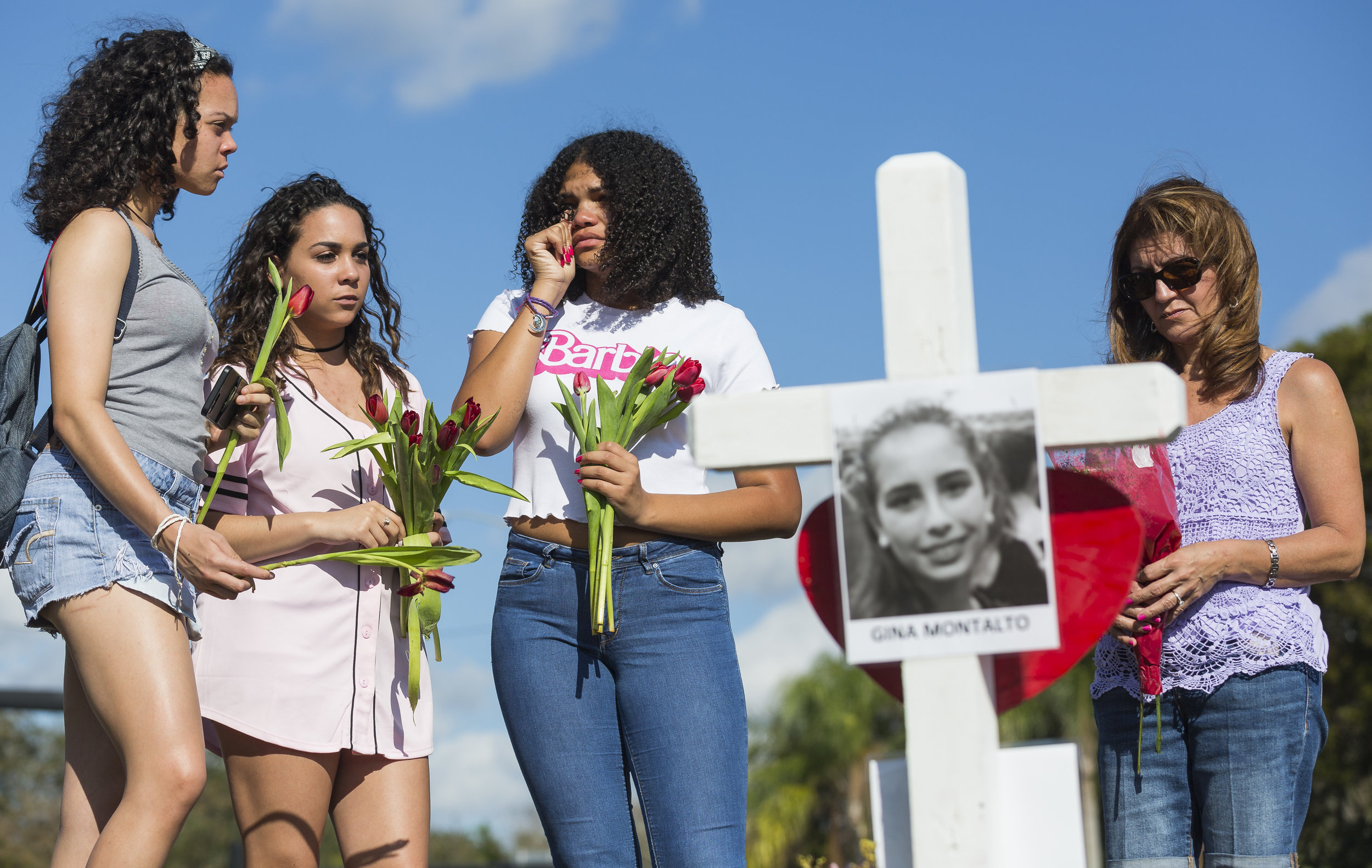  From left to right: Tatana Hobson 14, Annia Hobson 13, and Leilany Canate, 16, mourn in front of Marjory Stoneman Douglas High School in Parkland, Florida on Sunday, February 18, 2018. A gunman entered the school and killed 14 students and 3 teacher
