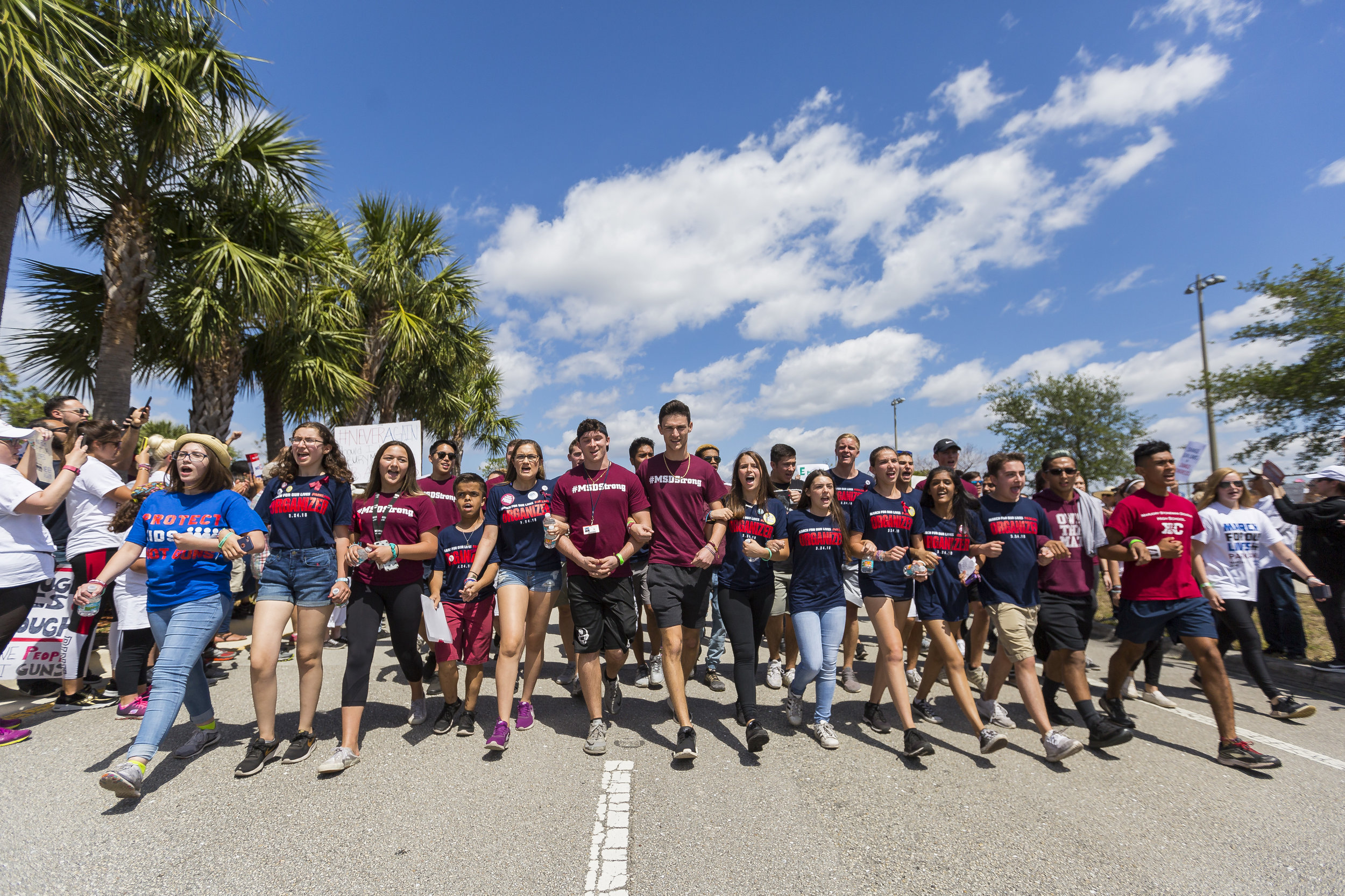 Marjory Stoneman Douglas High School students march toward their school while locking arms from Pine Trails Park in Parkland, Florida during the March for Our Lives protest on Saturday, March 24, 2018. 