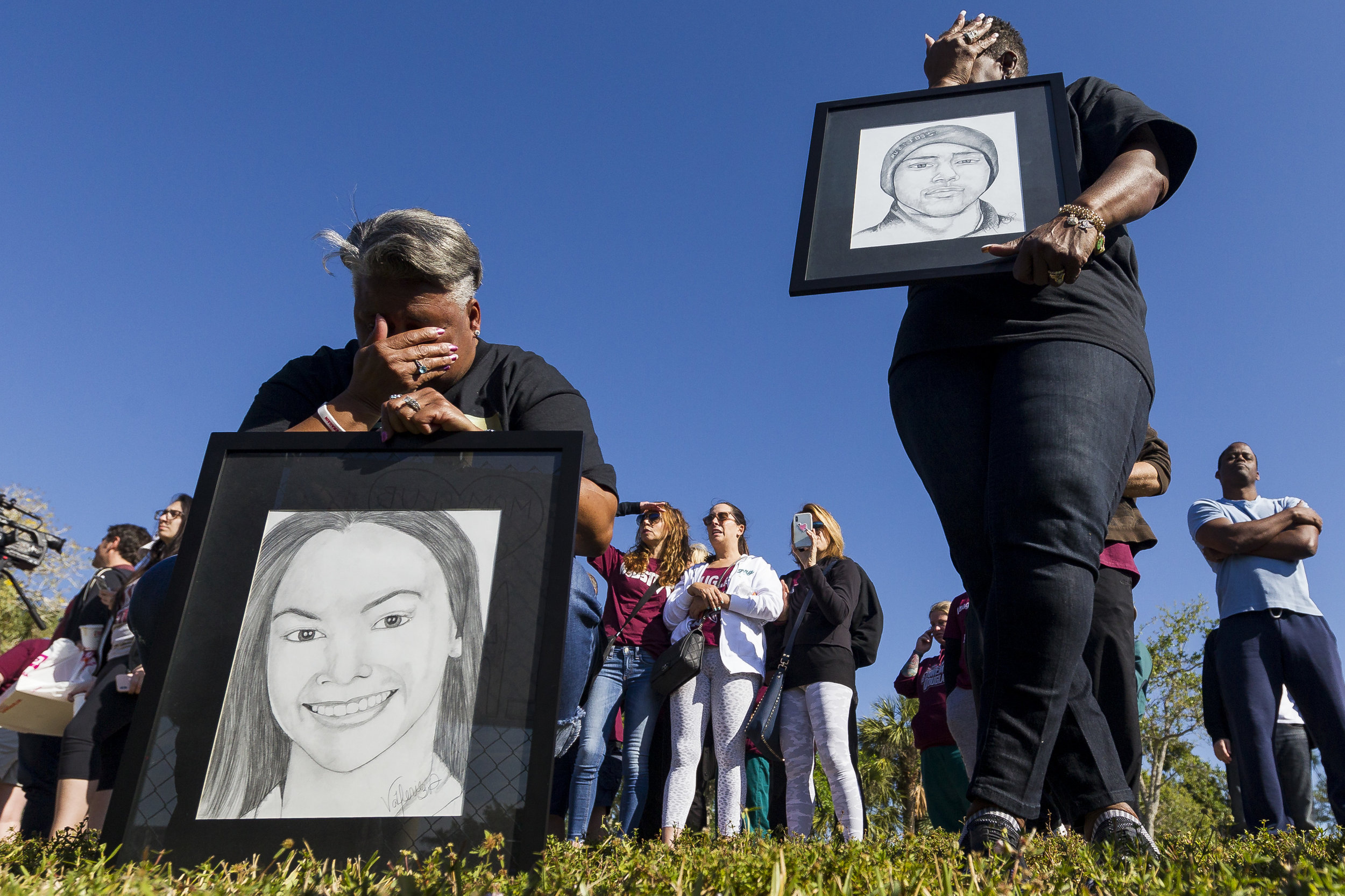  Pat Gibson, left, and Valerie Davis cry while holding drawings of two of the victims killed in the Parkland shooting during the one-month anniversary of the incident outside Marjory Stoneman Douglas High School on Wednesday, March, 14, 2018. 