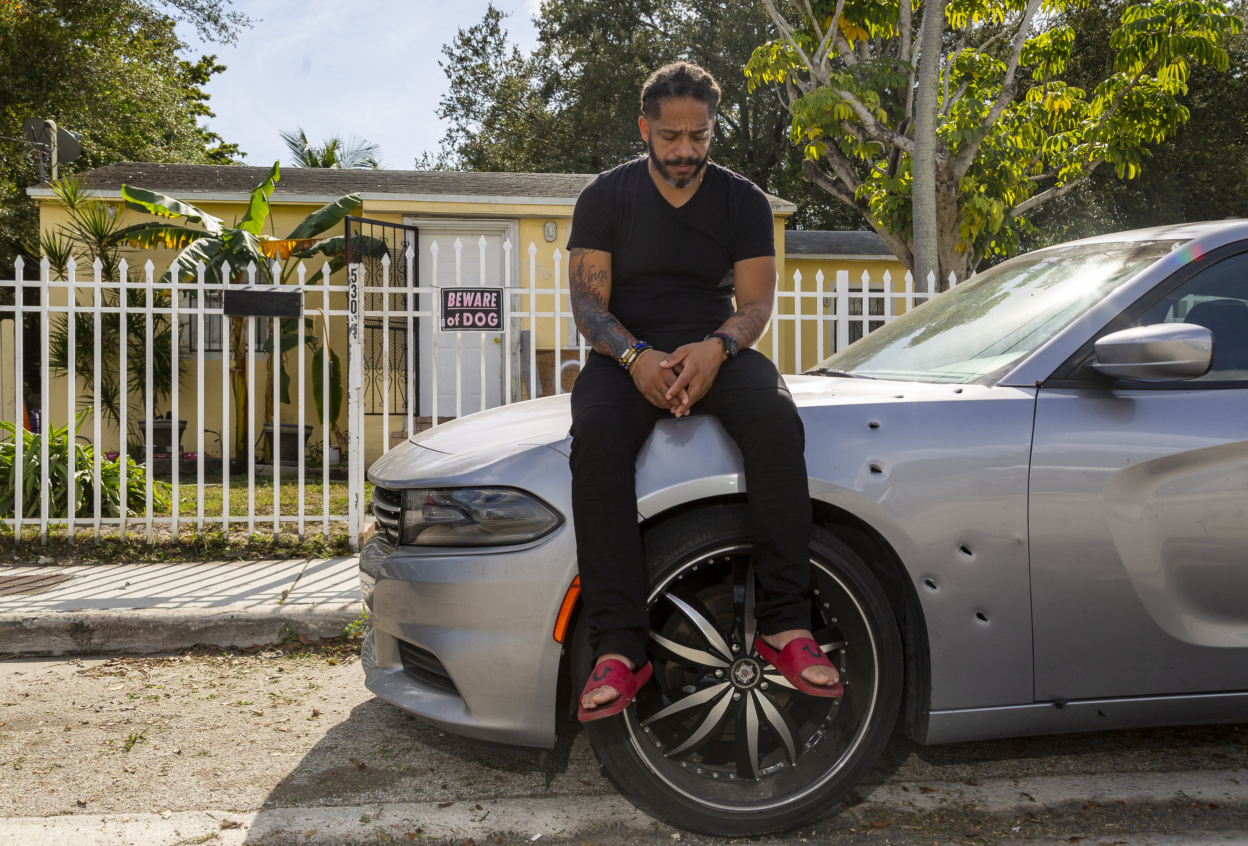  Free Rene Balbona, 39, a youth pastor, sits on his car in front of his home in Little Haiti on Saturday, January 19, 2019. Balbona's car and home were sprayed with bullets when his house got shot on November 28, 2018. Balbona's son, Isaiah, was kill