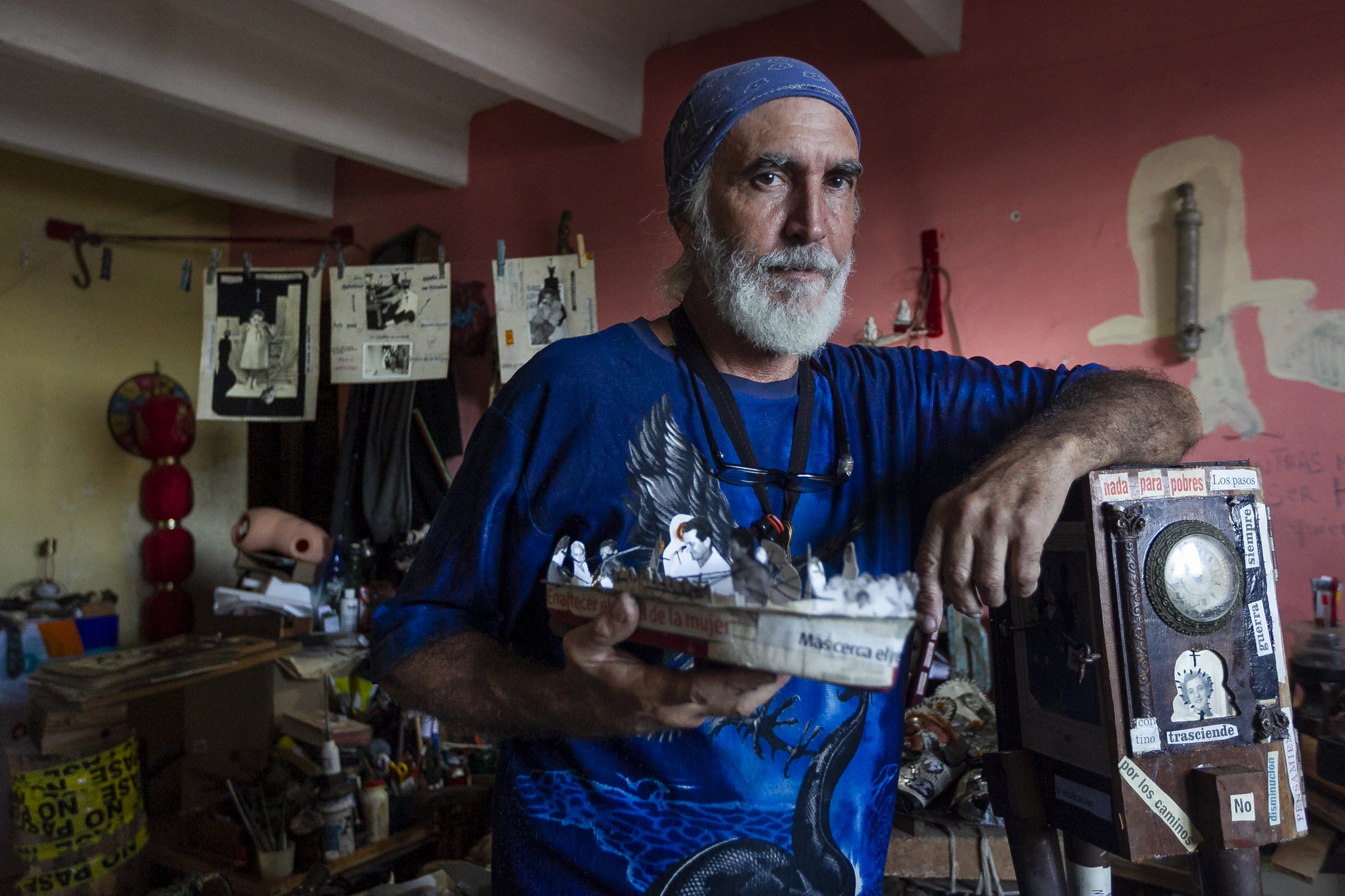  Jorge Alberto Hernandez Cadi, a Cuban outsider artist who lives in Alamar, holds a boat he created from paper and old photographs. Hernandez is known as "El Buso" (the diver) because he scavenges through the trash to find objects for his art. 