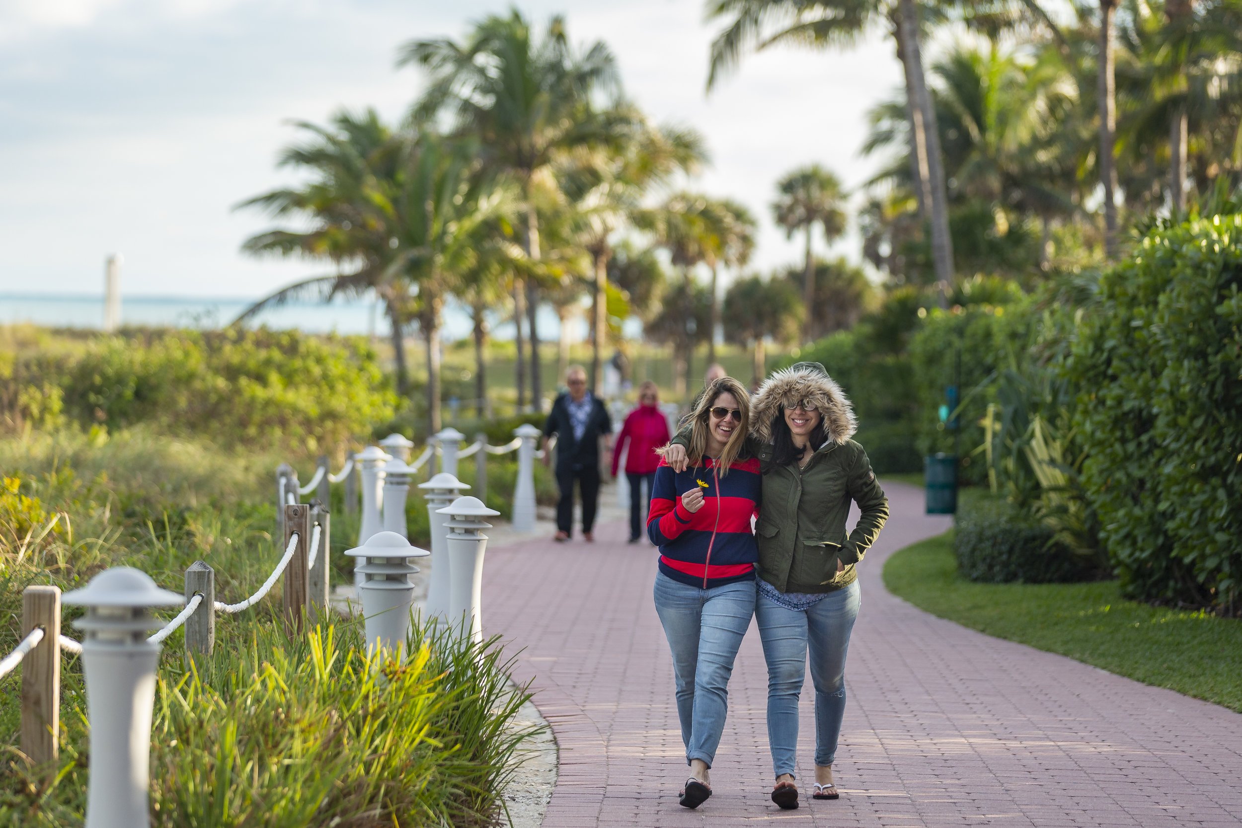  Regina Soares, left, and Rafaela Squiabel, both tourists from Boston, walk down a sidewalk near South Pointe Park Pier in Miami Beach as temperatures drop into the 50s on Monday, Jan. 28, 2019. 