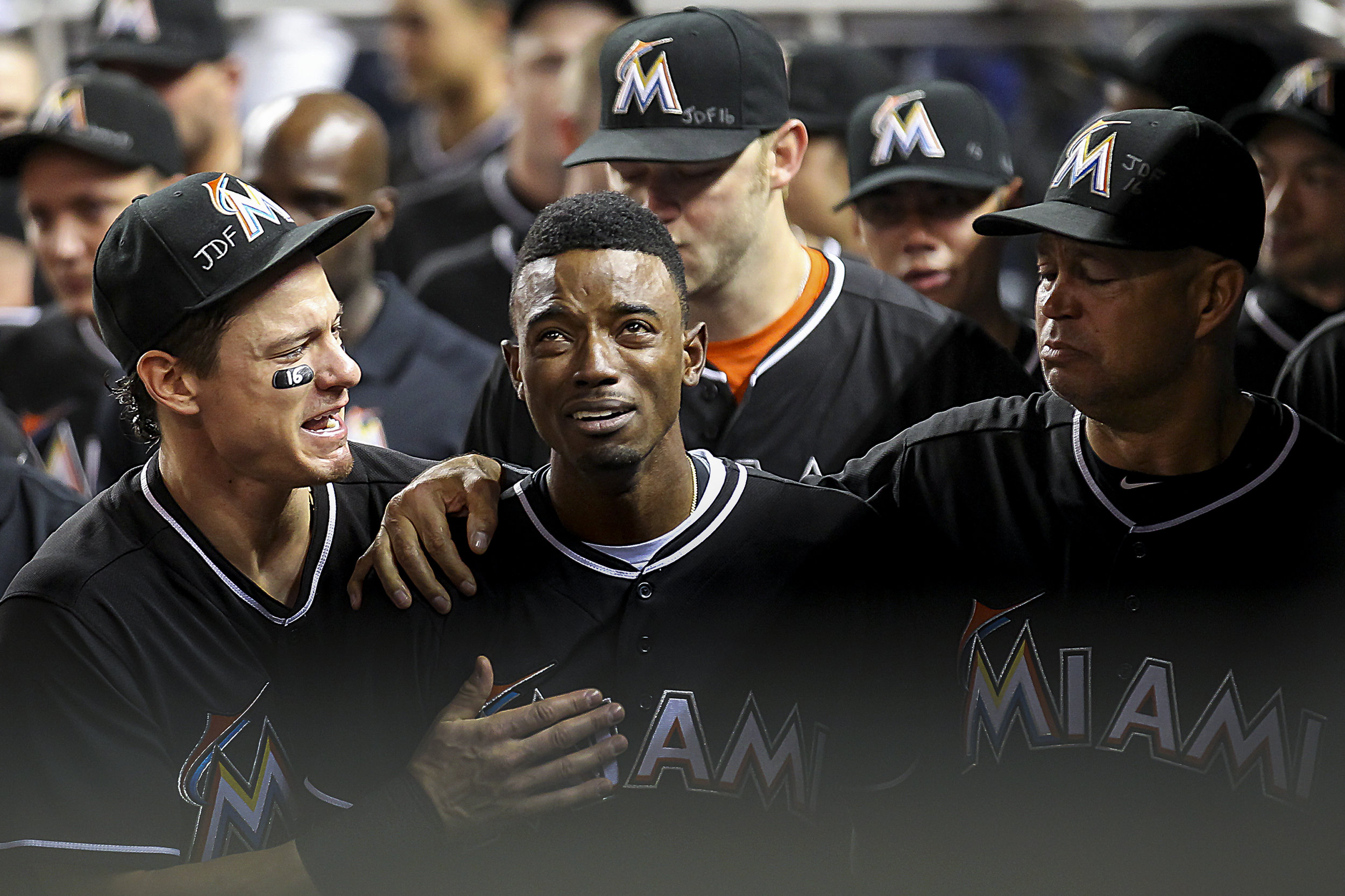  Miami Marlins' Dee Gordon (9), center, is comforted by Derek Dietrich (32), left, after hitting a home run during the first inning of a baseball game against the New York Mets at Marlins Park in Little Havana on Mon., Sept. 26, 2016. This is the fir
