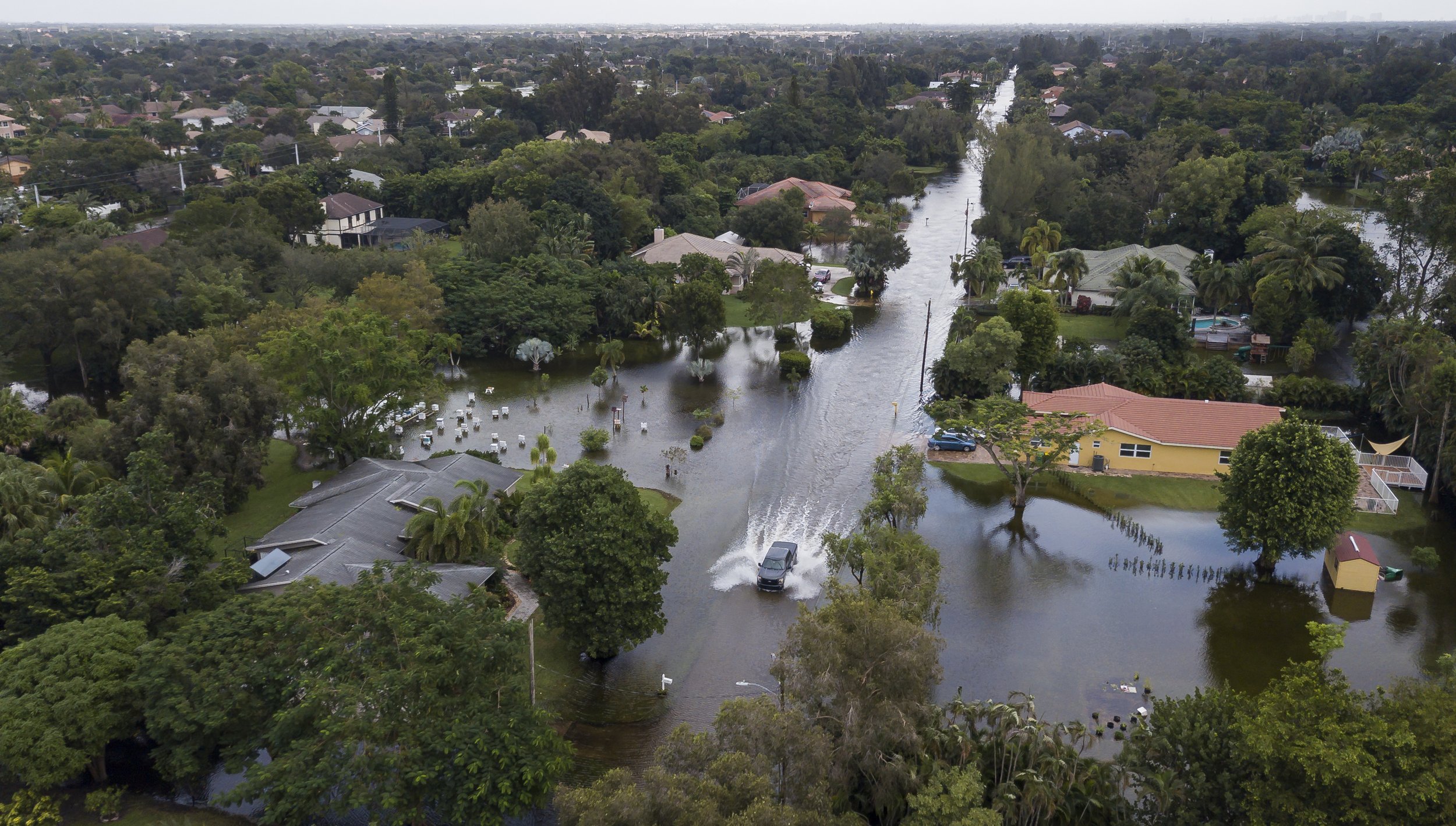  A car drives through a flooded street in a residential neighborhood in Plantation, Florida on Monday, November 9, 2020. Tropical Storm Eta made its way past South Florida Sunday night leaving roads and neighborhoods flooded. 