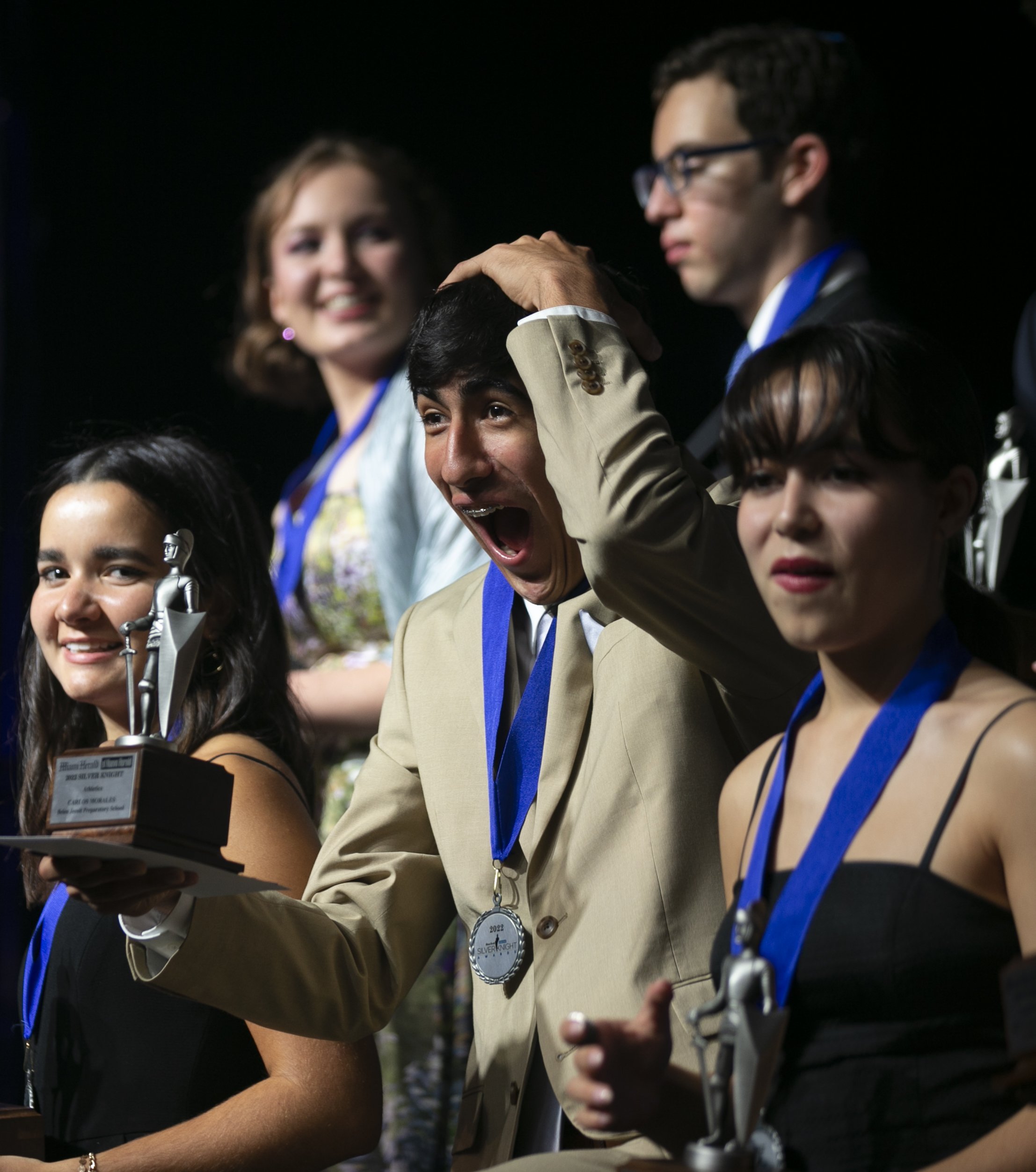  Silver Knight winner in Athletics Carlos Morales, center, from Belen Jesuit Preparatory School, center, reacts during the Miami Herald &amp; el Nuevo Herald 64th Silver Knight Award Ceremony at the James L. Knight Center in downtown Miami, Florida o