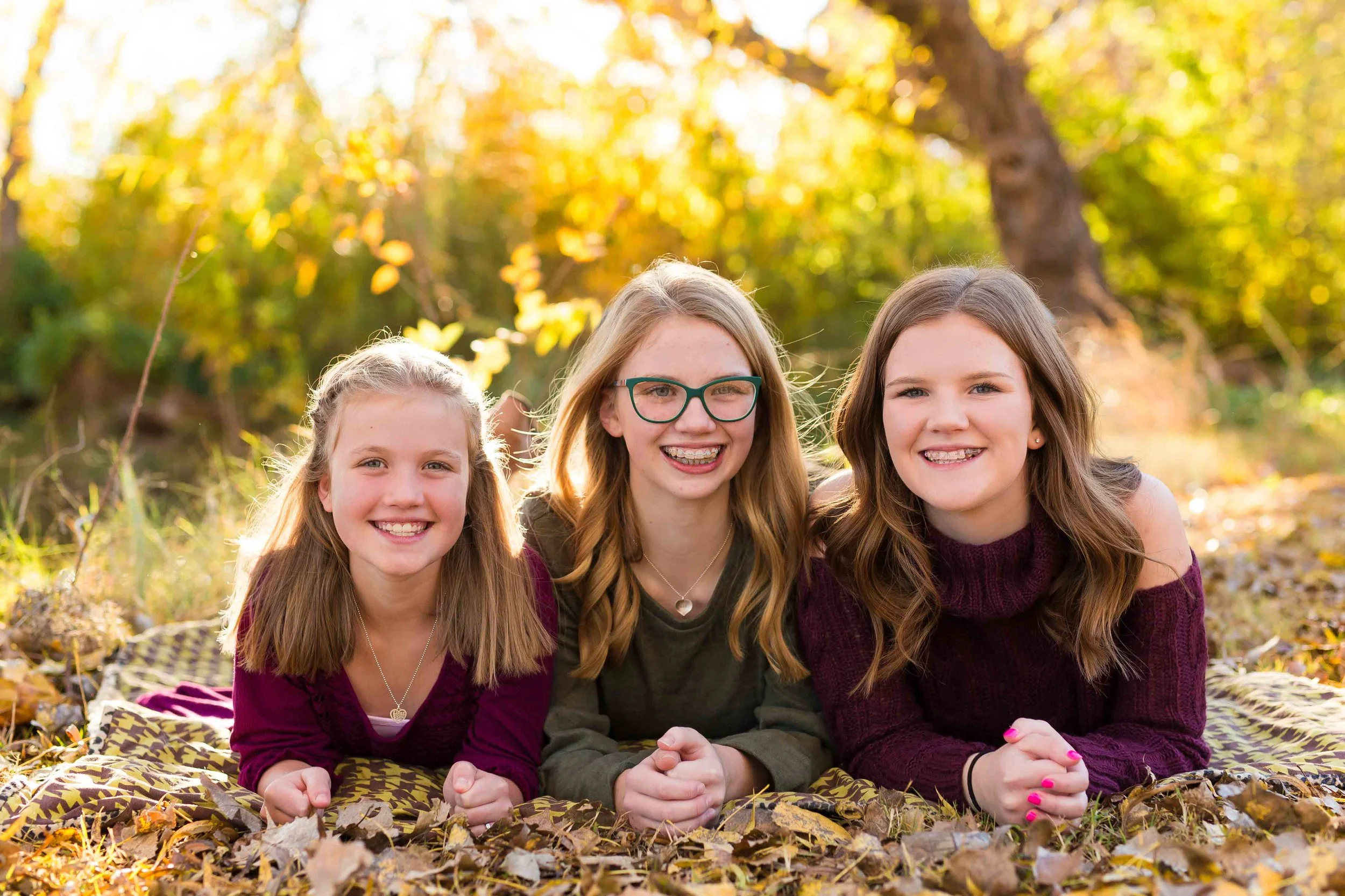 Truly You Photography Oklahoma tweens three girls laying and smiling in leaves