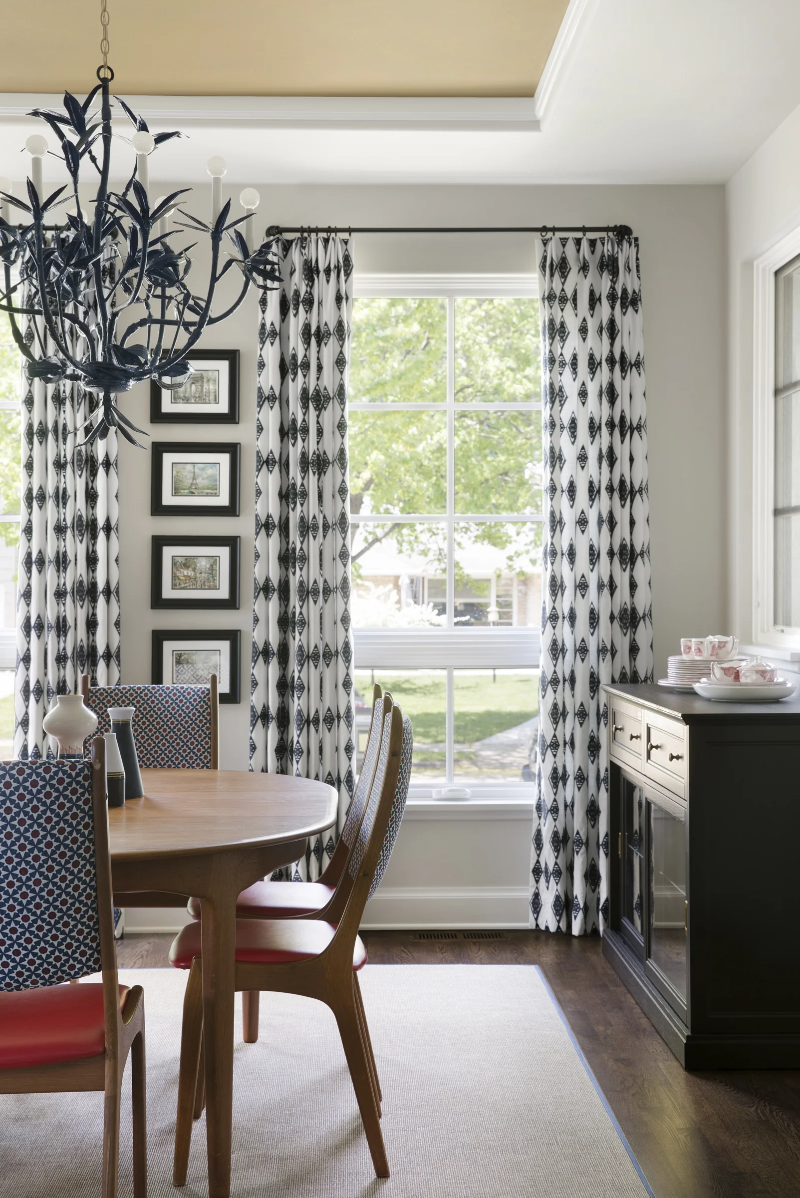 After: We also treated the windows as two units, each with a pair of drapes, instead of framing the entire wall with two panels. I love the sliver of wall leftover, perfect for a stack of prints picked up on a vacation.