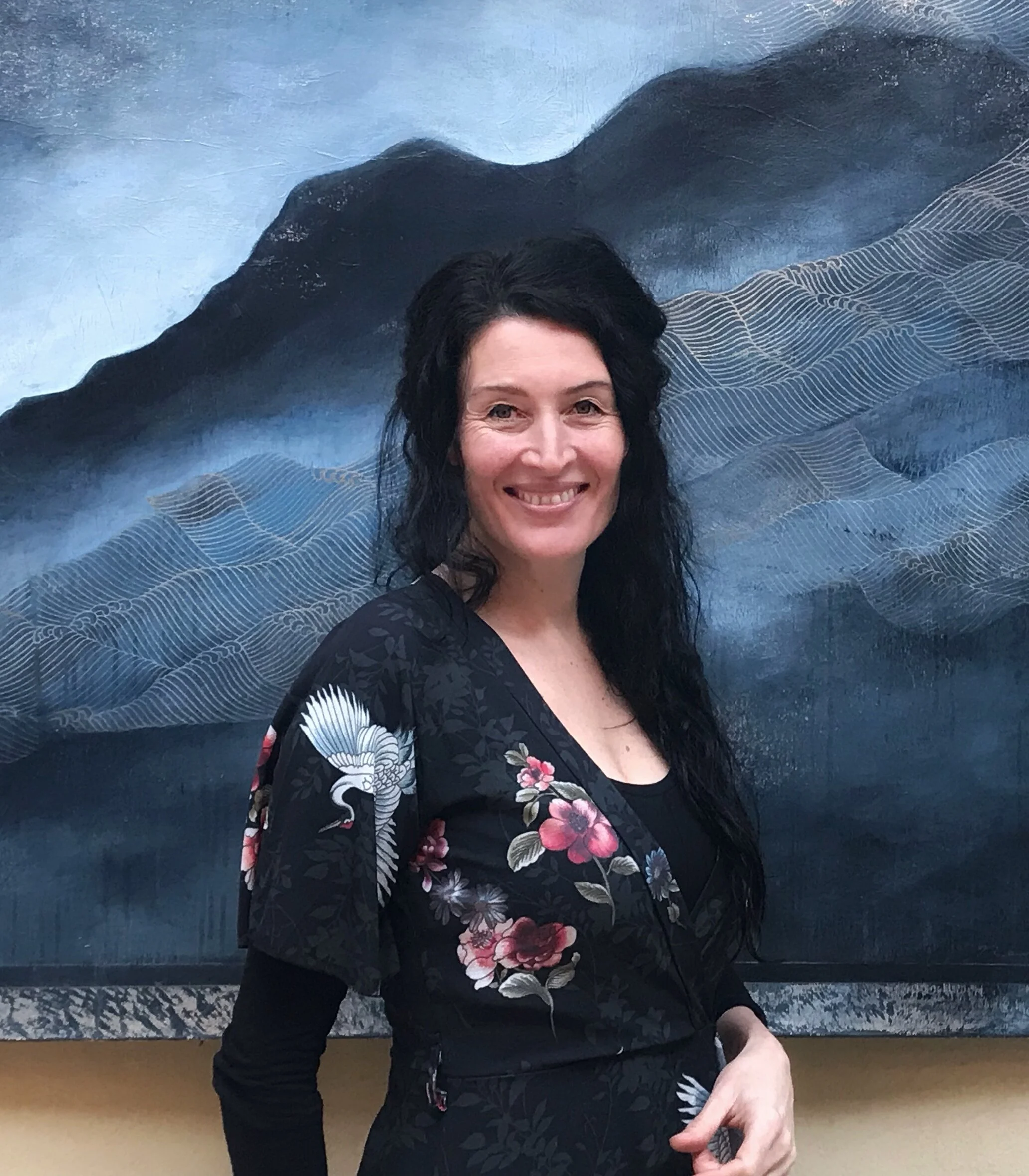 Nerina Lascelles standing before one of her paintings