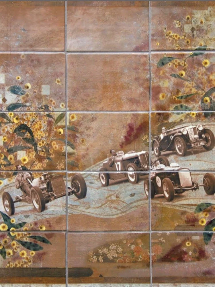 Rob Roy Hillclimb A decorative tile mural featuring vintage race cars and yellow floral patterns on a reddish-brown background.Eltham Cemetery