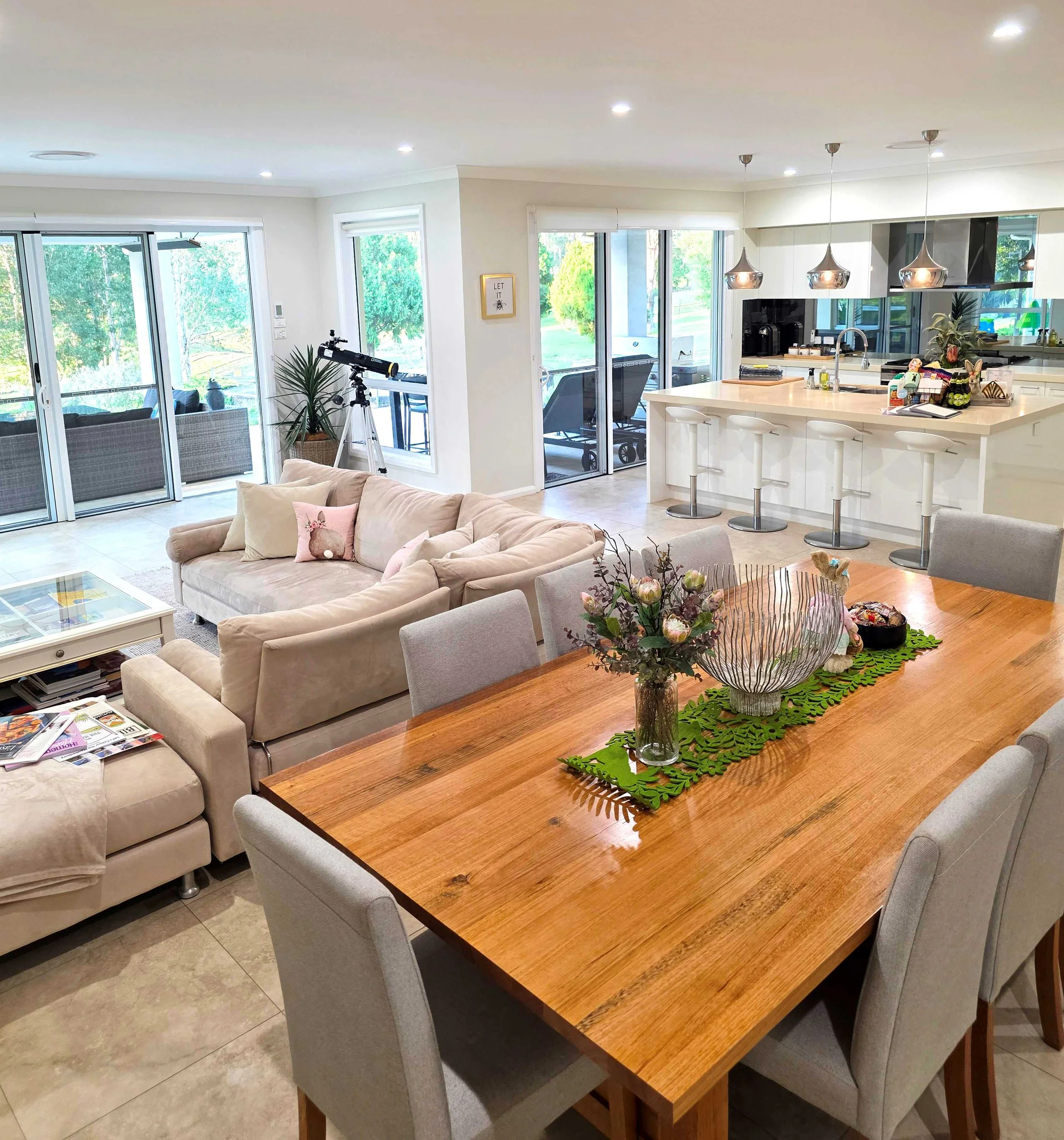 Spacious open-plan living area at Dido’s Place featuring a large dining table, modern kitchen with breakfast bar, comfortable lounge and views to private outdoor entertaining areas in the Hawkesbury.